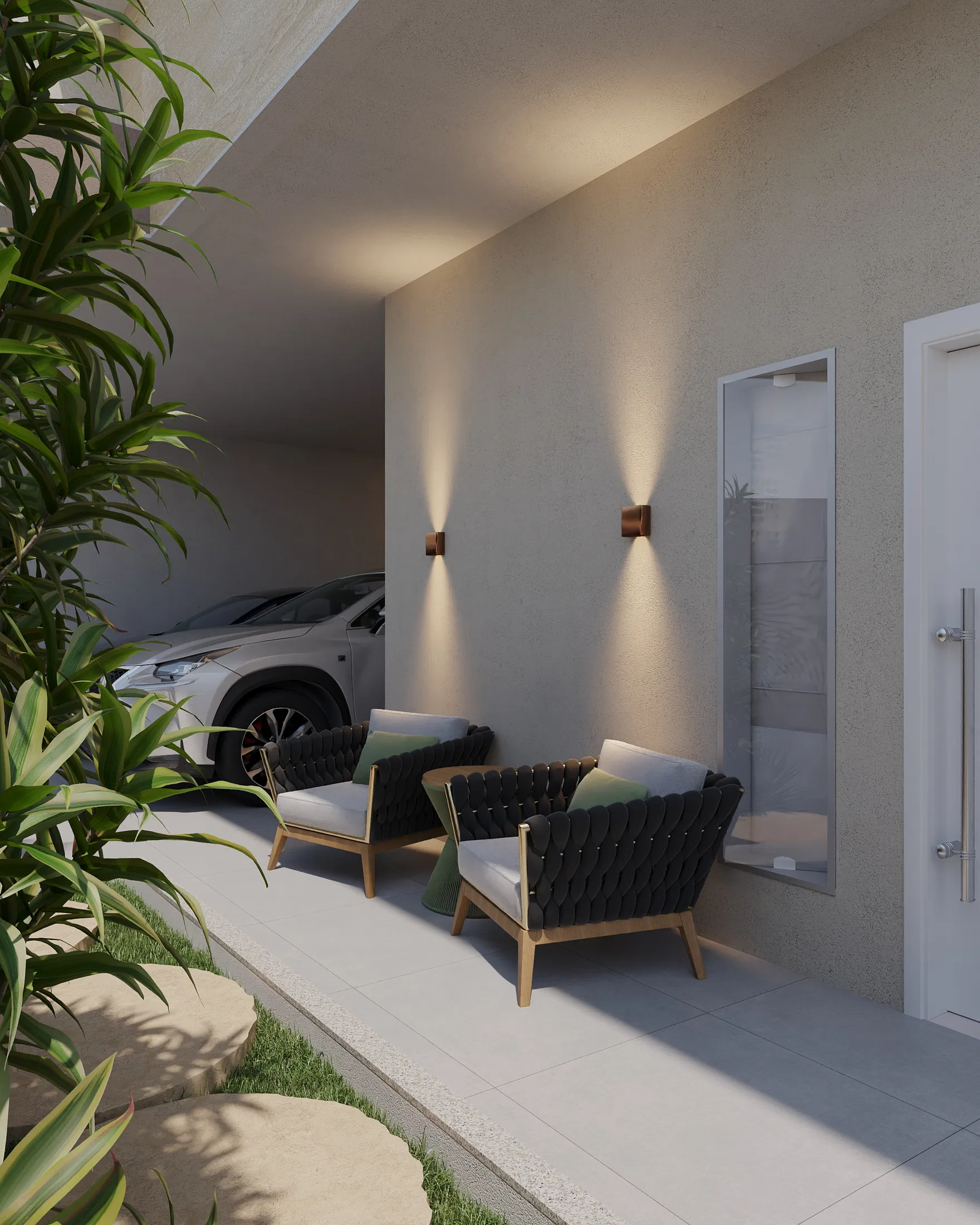 Side view of the outdoor seating area with black woven armchairs, lit wall sconces and a glass gate beside the garage