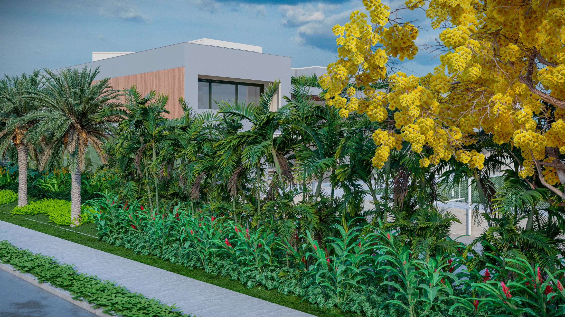 Jardim voltado para a rua com cerca-viva tropical e uma árvore de flores amarelas em primeiro plano, casa branca ao fundo.