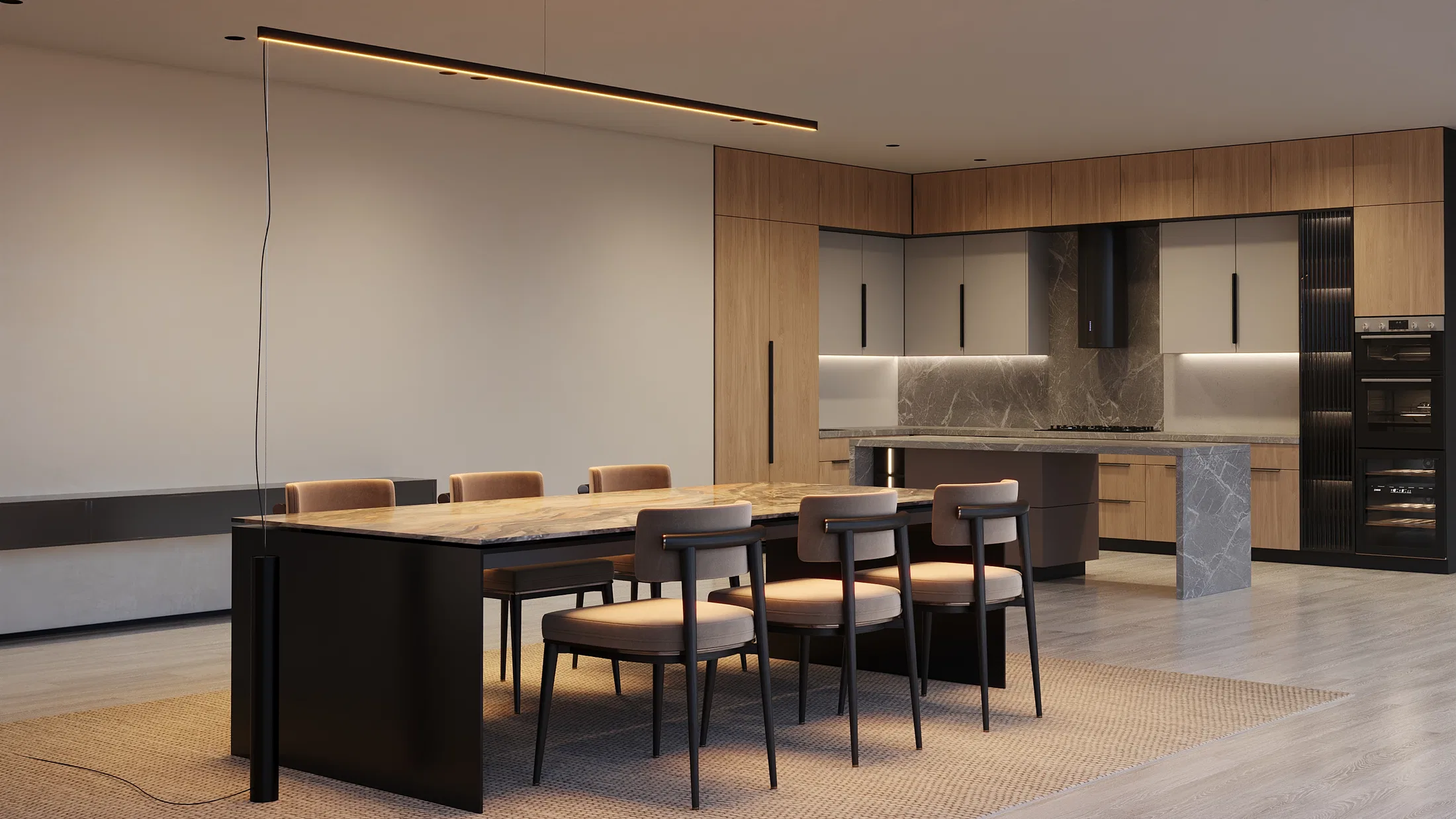 Integrated kitchen with wood cabinetry and a marble island in the background, a stone dining table with upholstered chairs and a lit linear pendant fixture above.