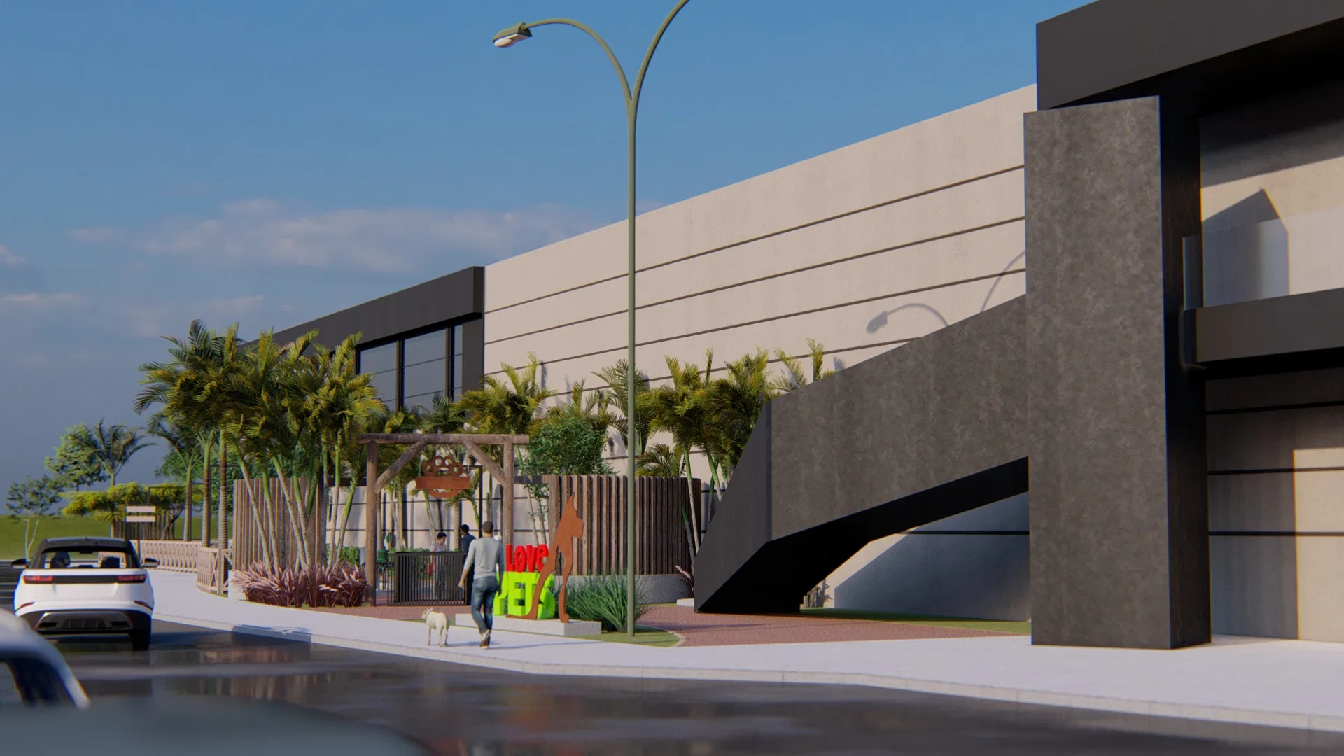 Windowless mall facade seen from the street, an angular ramp, a planted strip of palms, colourful pet signage and a person walking a dog
