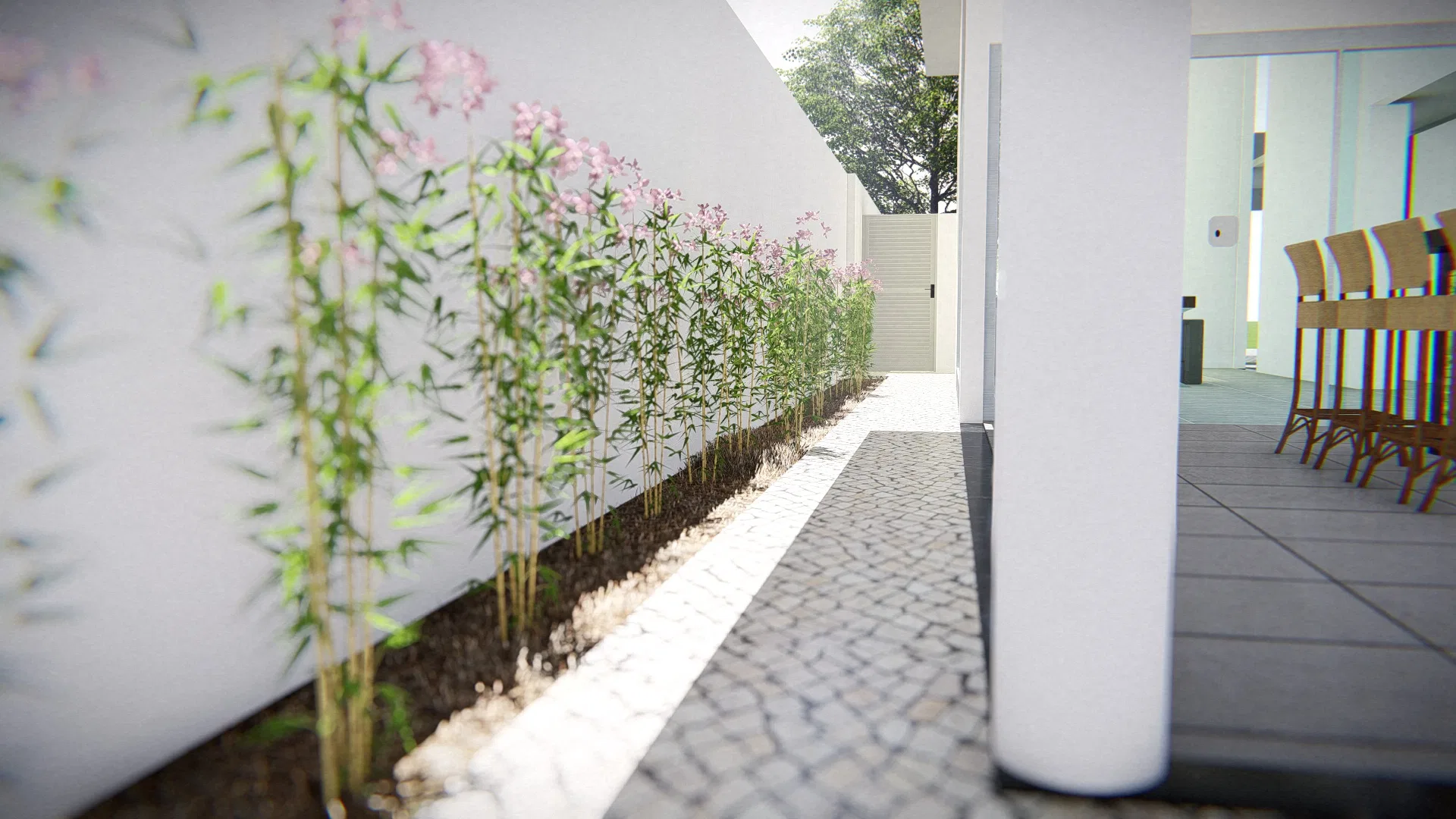 Side corridor in Portuguese stone, with a bed of bamboo and pink flowers along the white wall and a dining area glimpsed at right