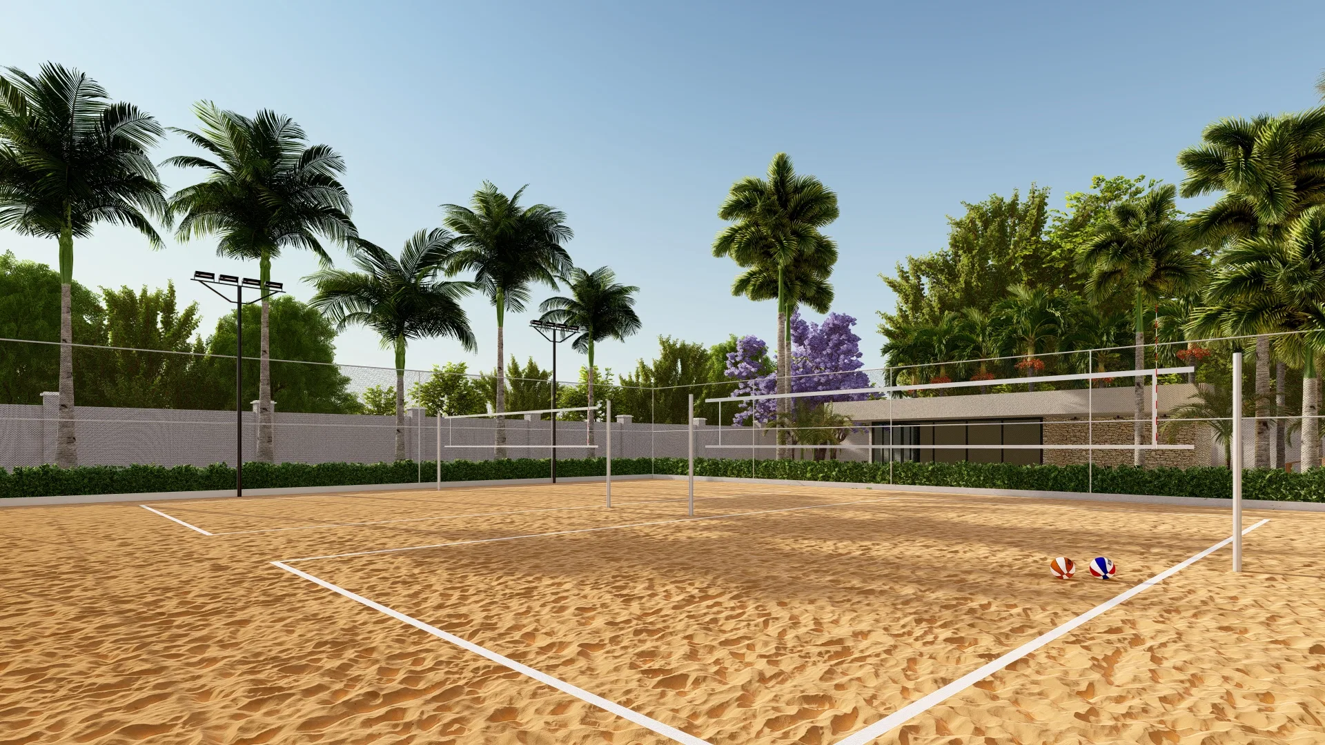 Sand volleyball court with nets and light poles, ringed by palms and a lilac-flowering tree in the background