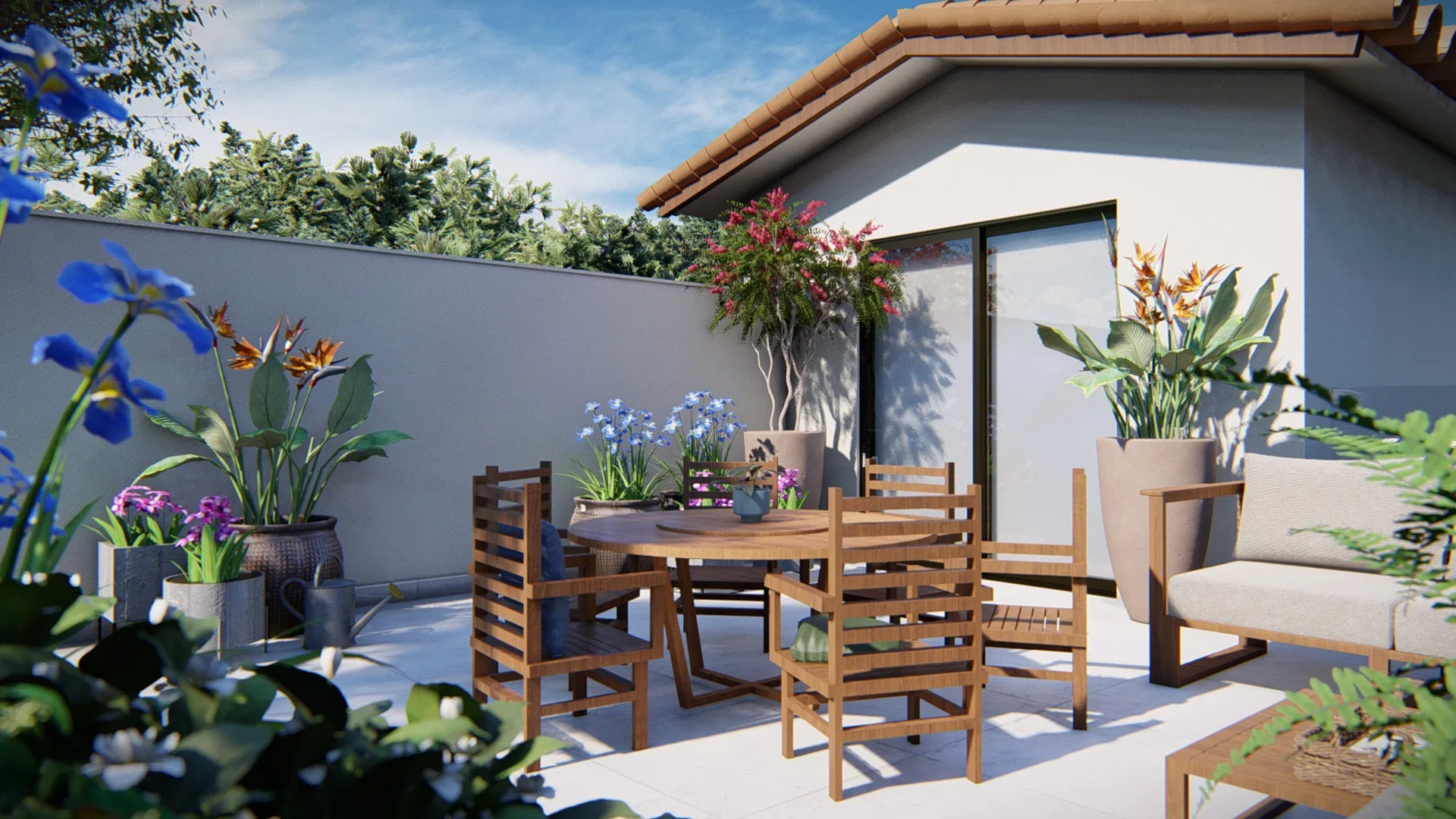 A terrace with a round timber table and chairs, pots of blue iris and birds of paradise, before a covered area with glass doors under a blue sky.