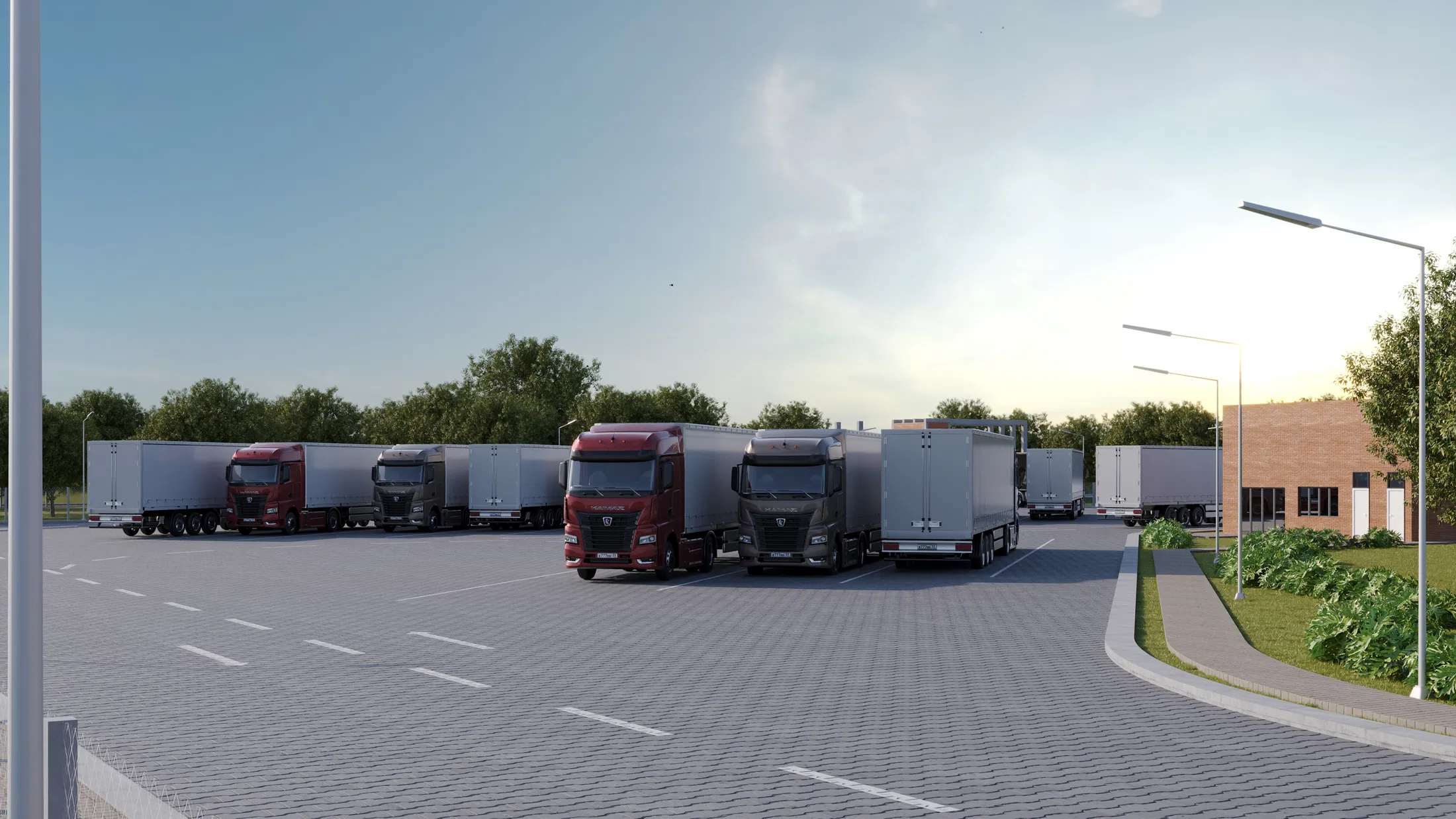 Maneuvering yard at dusk with tractor-trailers parked in bays, lighting poles and a line of trees in the background.