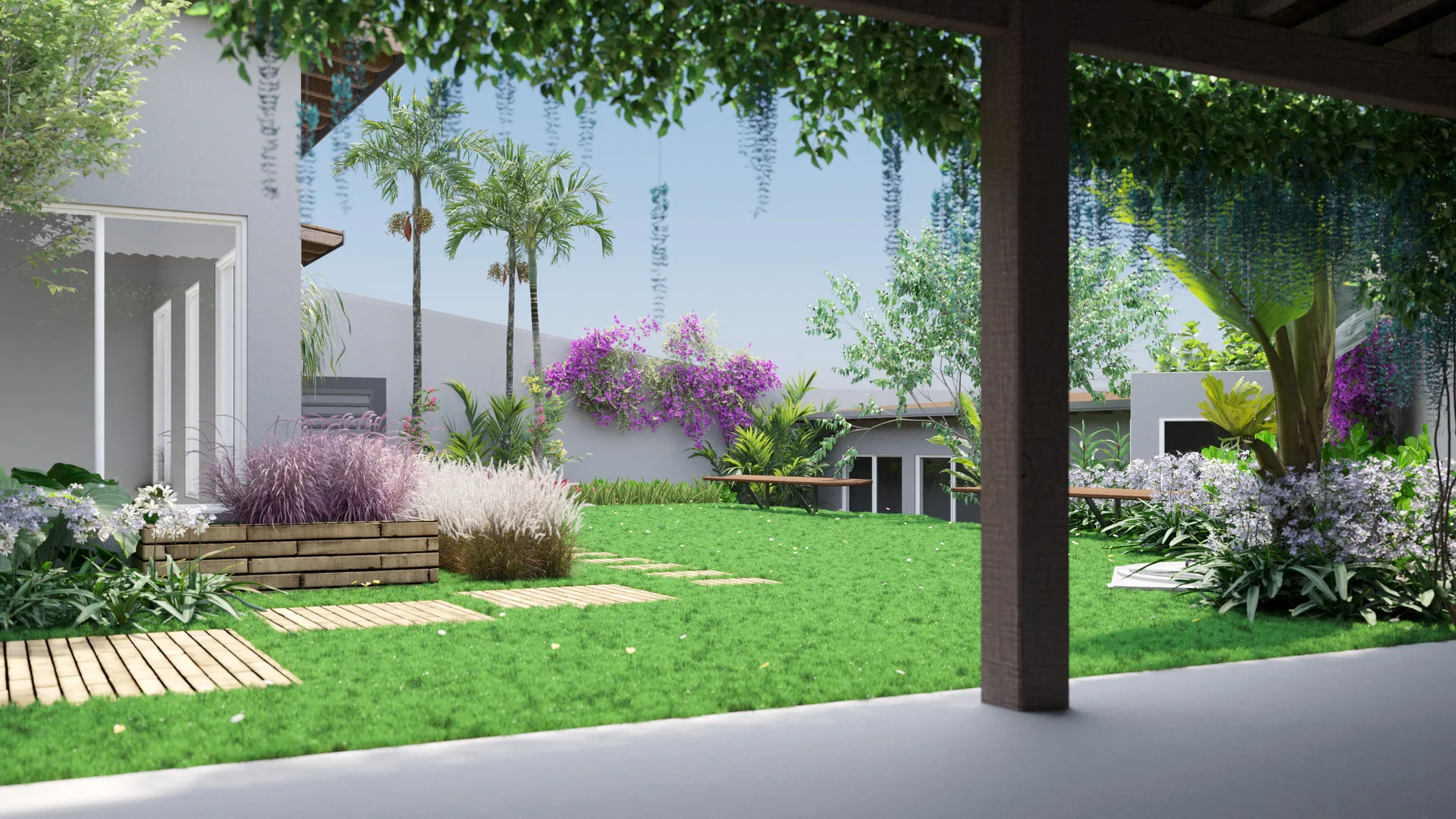 View from beneath a pergola out to the garden, with palms, bougainvillea over the wall, grasses in a wooden planter and a timber path.