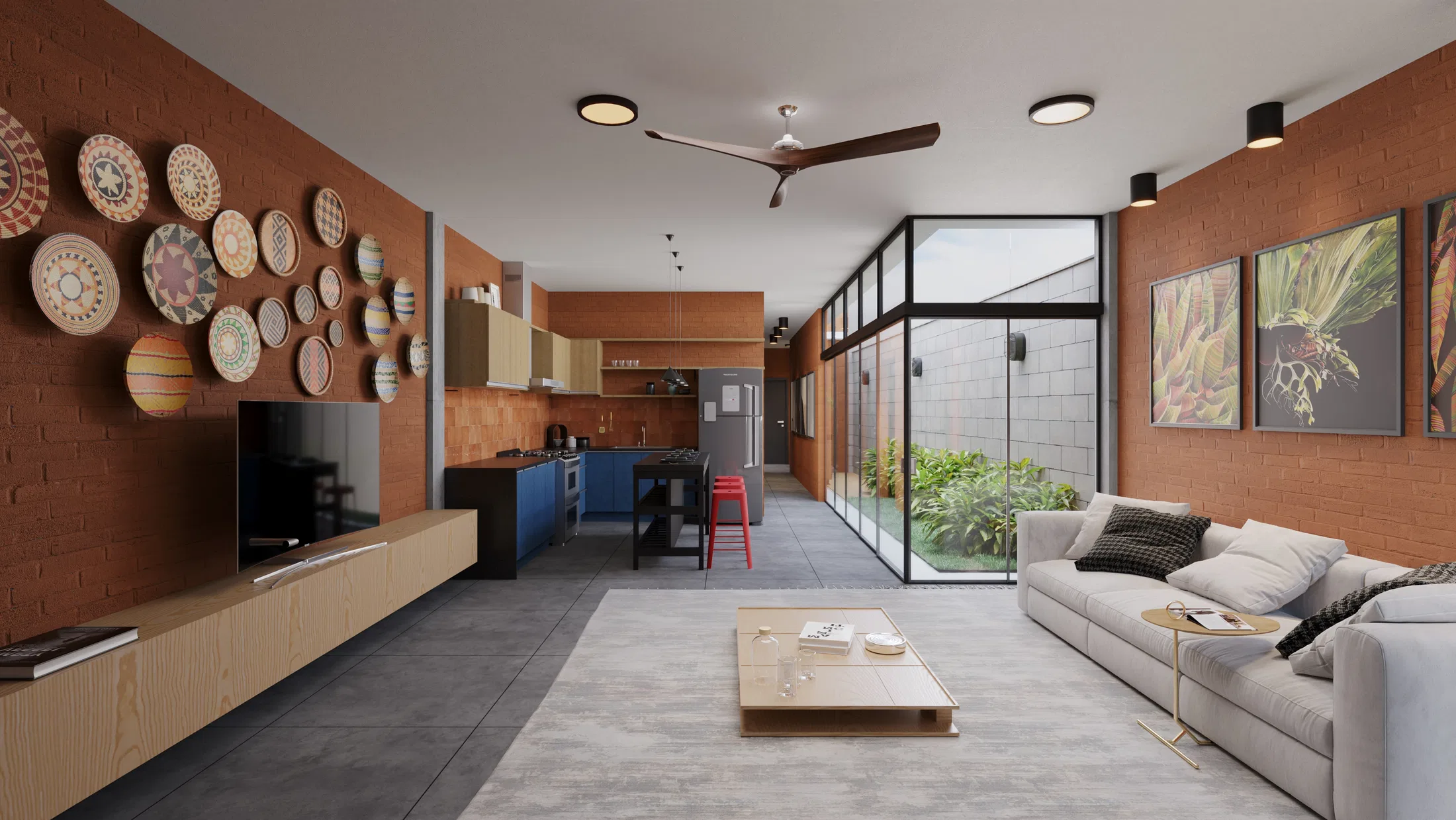 Open-plan living and kitchen with a brick wall of decorative plates, grey sofa, low coffee table and a glazed courtyard beyond