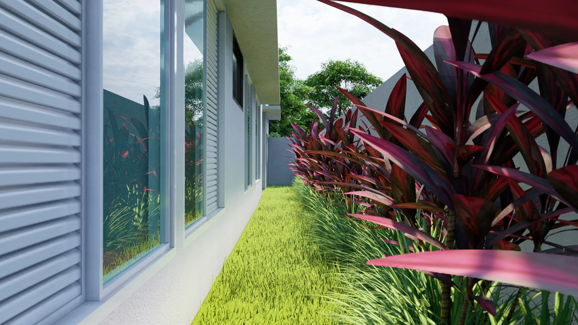 Side corridor with glass windows and pale louvers reflecting the garden, a strip of grass and a bed of red foliage running along the wall