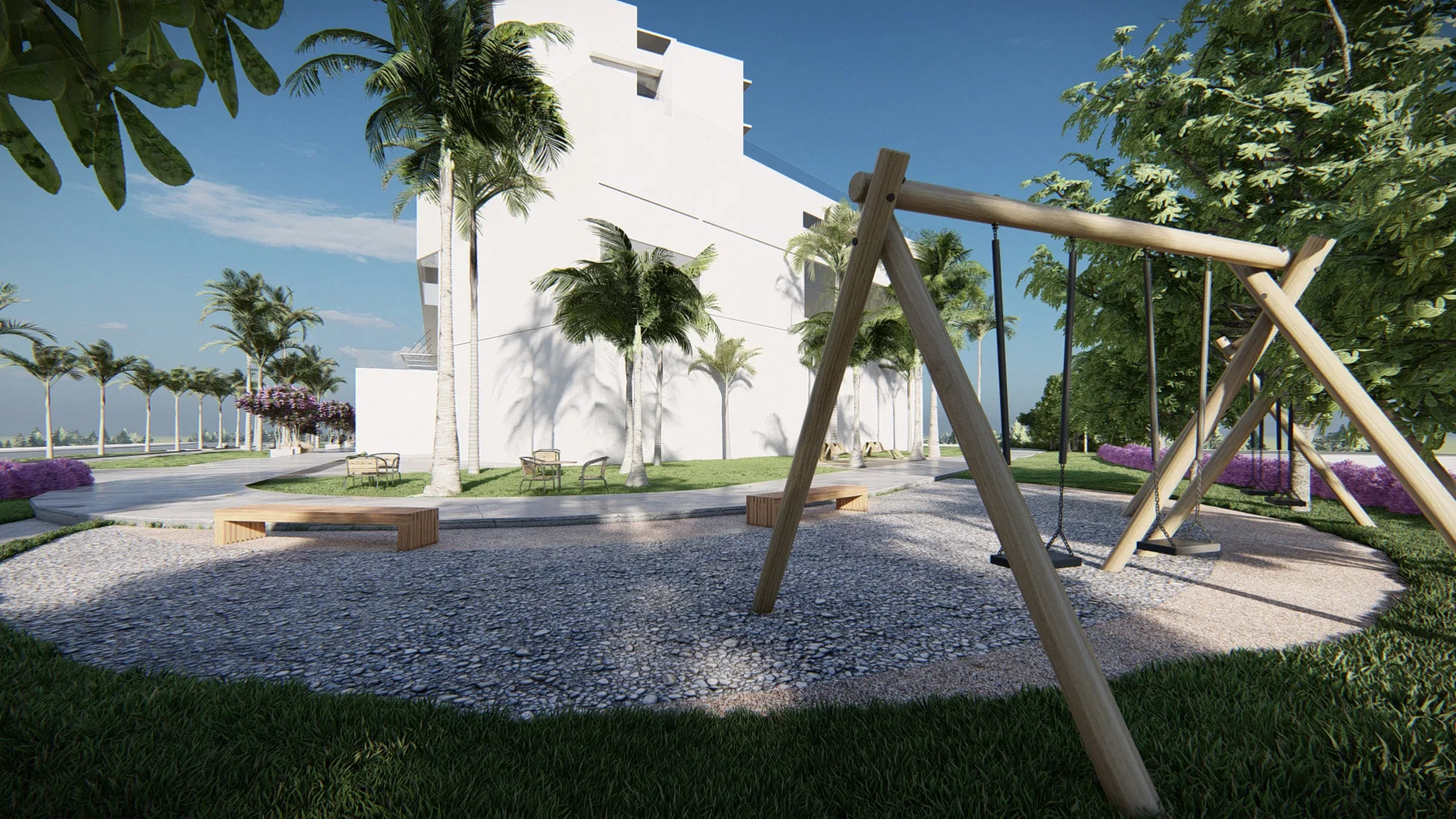 Playground with a wooden swing set on a pebble floor, flanked by benches and coconut palms, the white building behind.