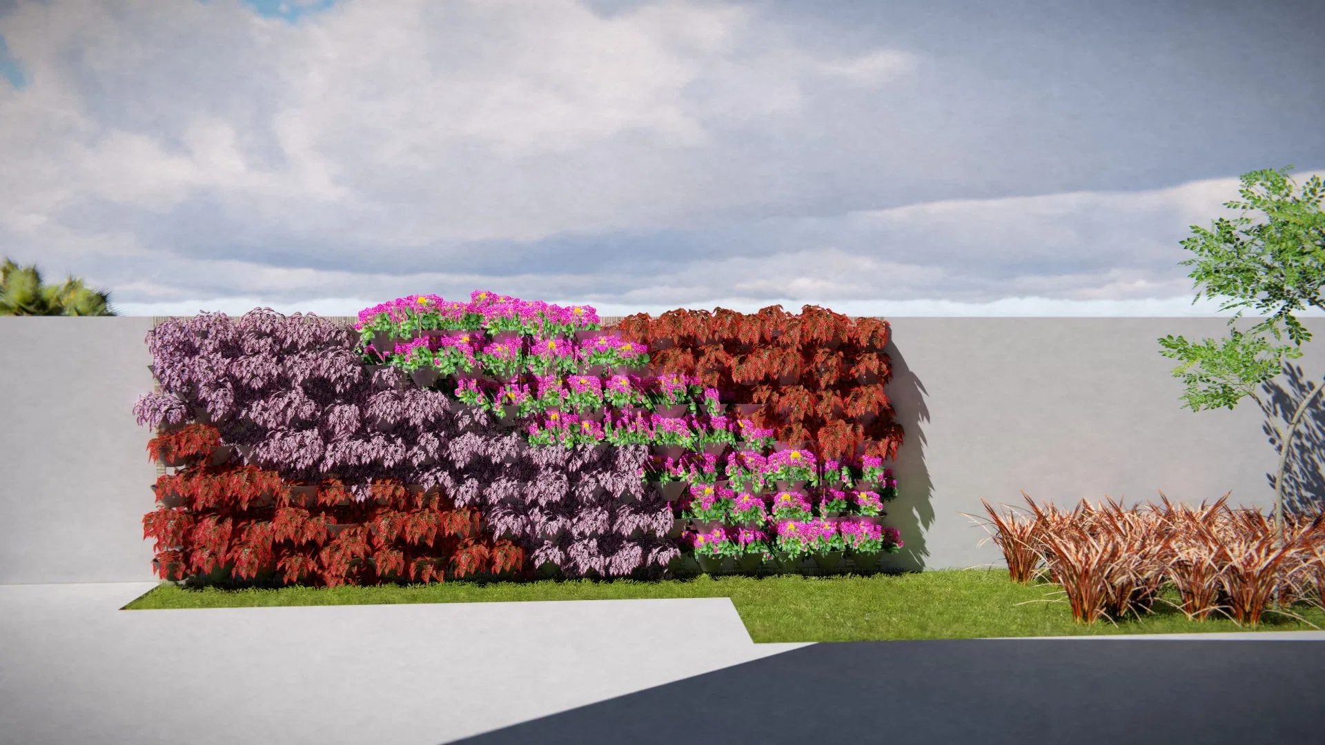 Vertical flowering panel in a mosaic of purple foliage, magenta blooms and red leaves on a white wall, with coppery grasses beside it.