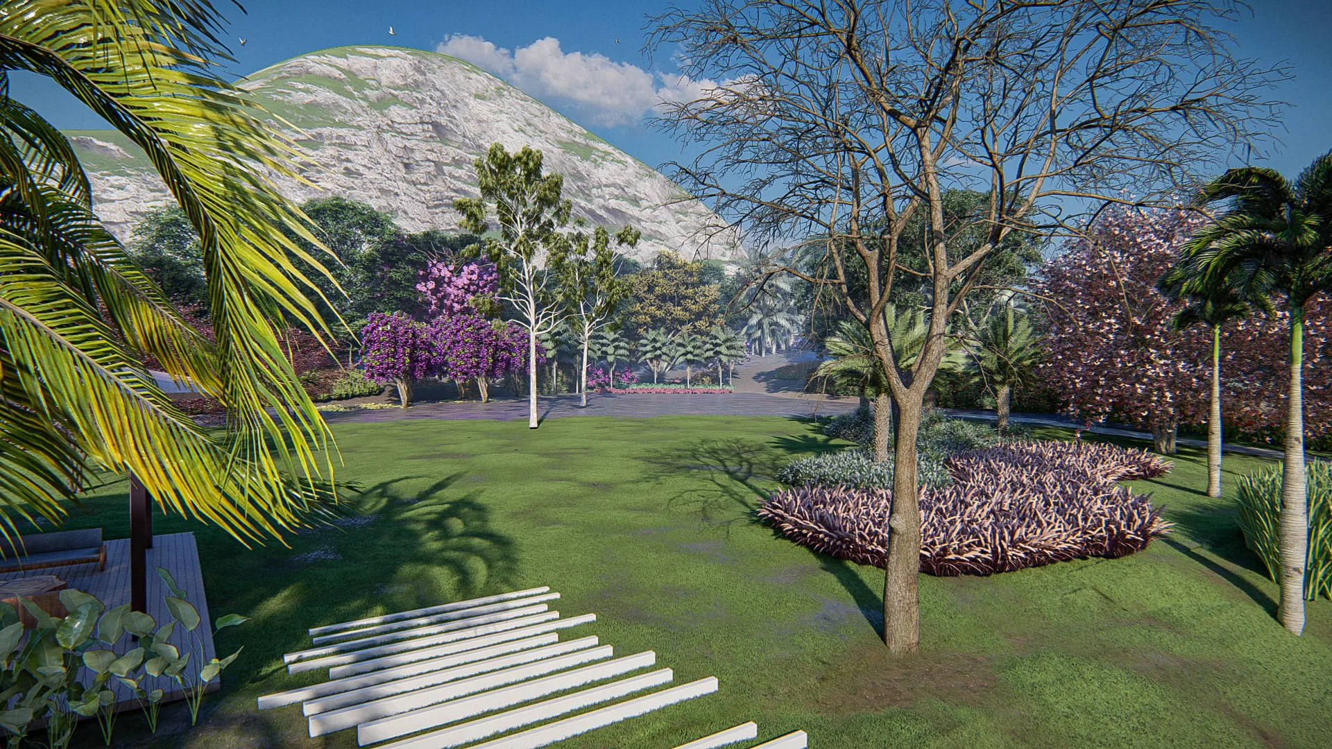 Wide garden lawn with purple-flowering trees, a bare tree in the foreground and a foliage bed behind, mountains on the horizon.