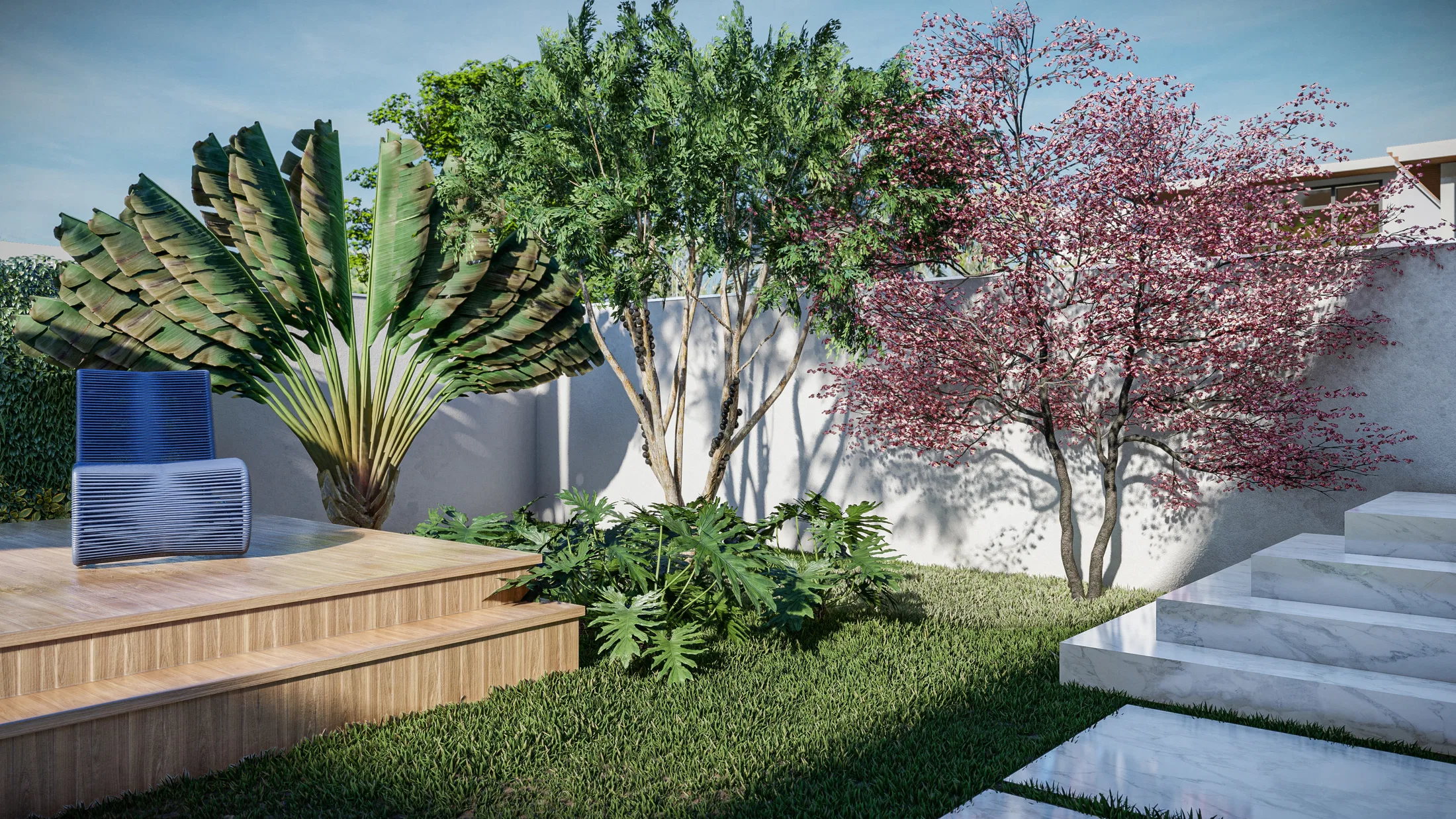 Wooden deck in the backyard with an upholstered chair, a fan-shaped tropical leaf and a pink-flowering tree by the wall