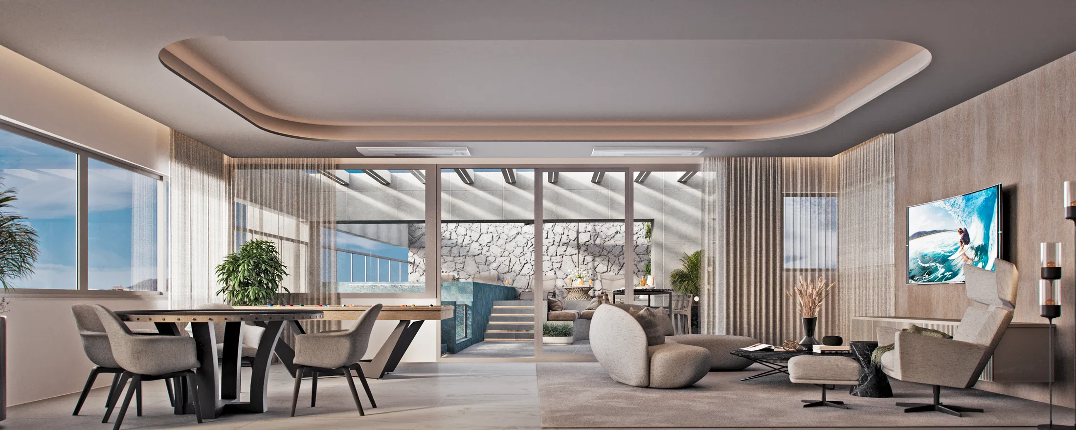 Indoor living and dining area with a cove-lit ceiling, a sculptural curved sofa and glass doors opening to the pool terrace and stone wall.