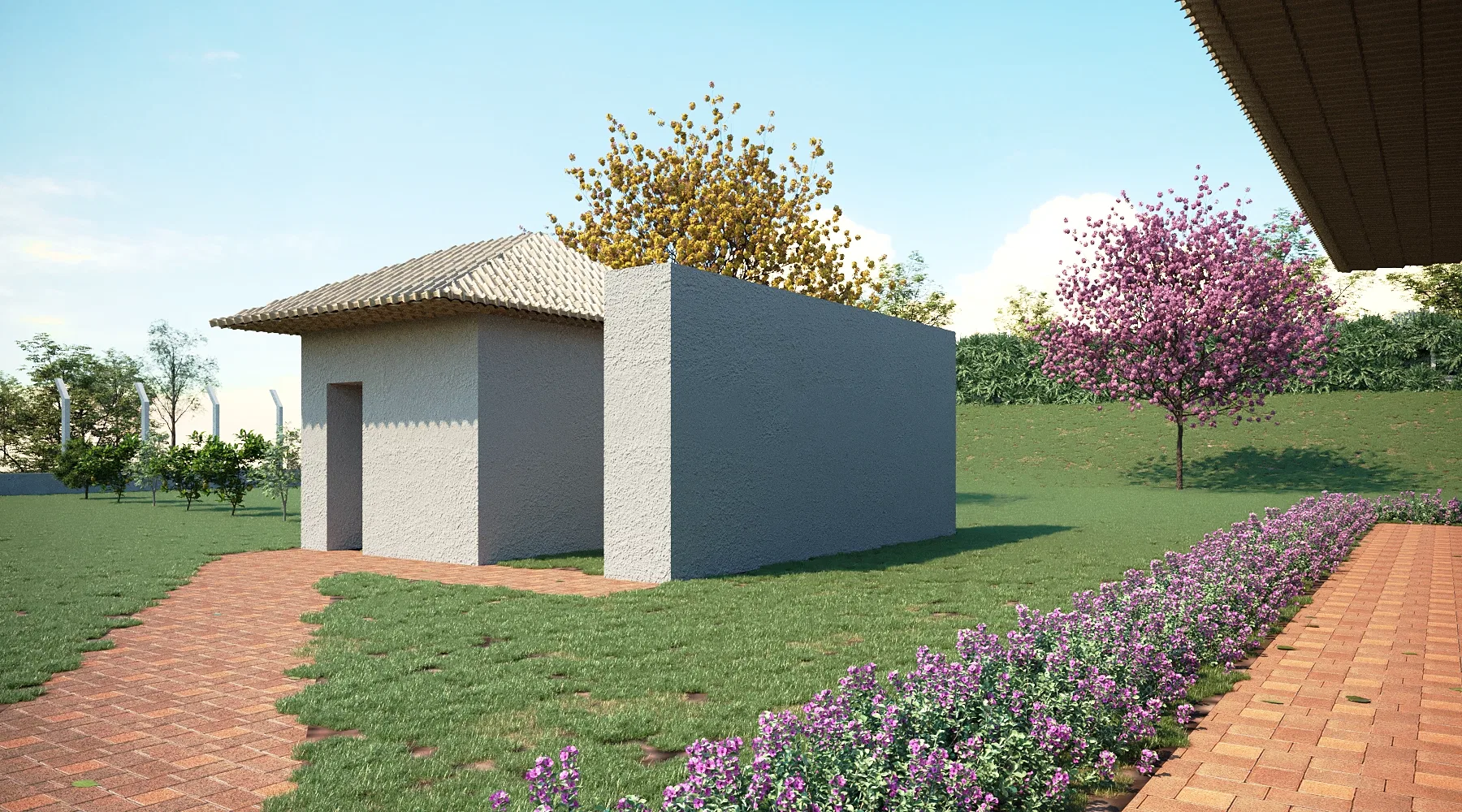 A small utility building with a roof over its door, a brick path, a bed of purple flowers and trees in yellow and pink bloom.