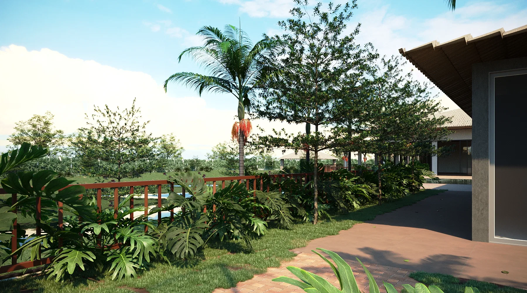 Garden seen from a deck with a timber railing, tropical foliage, a flowering palm and a brick path leading toward the house.