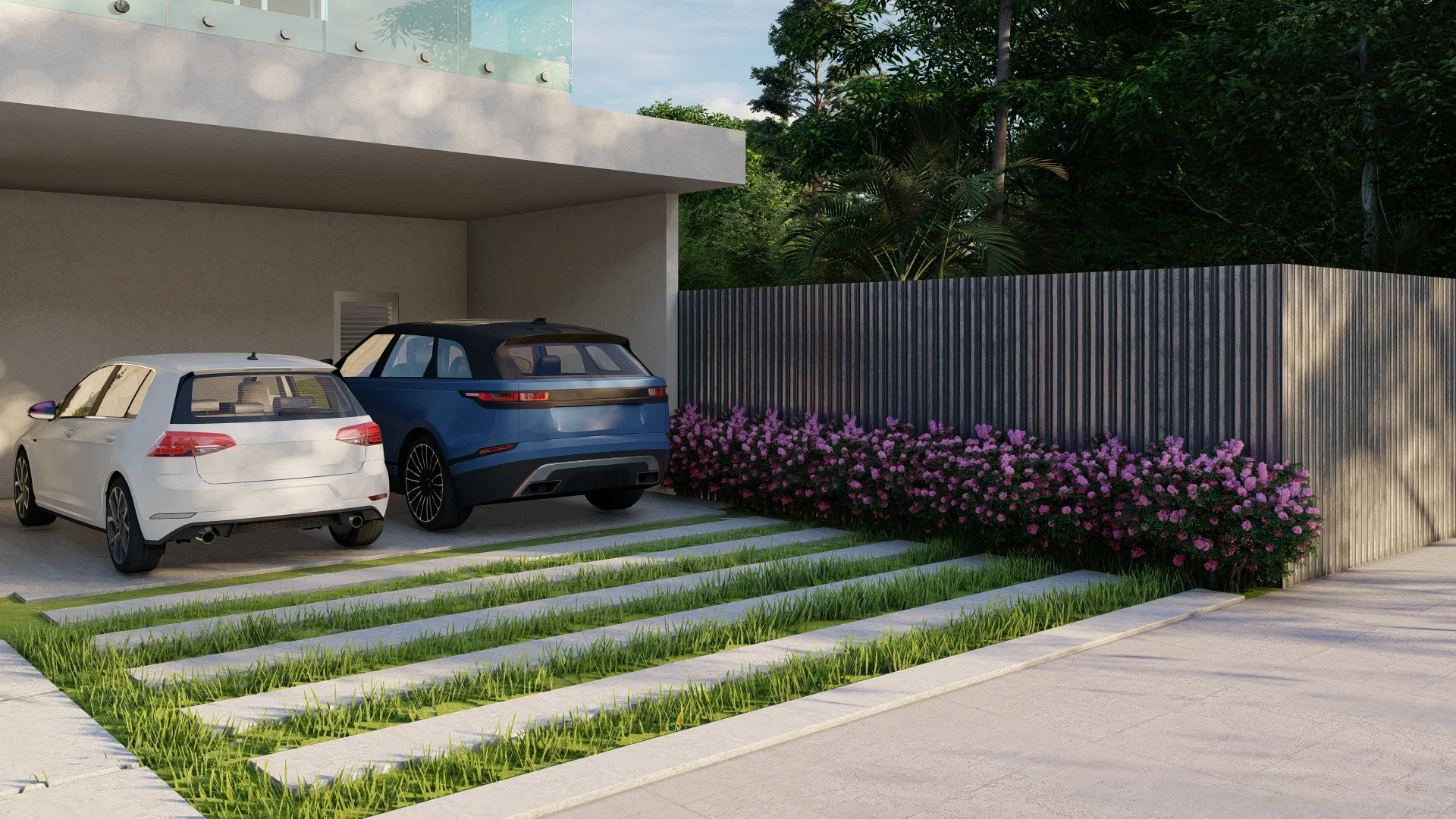 Vehicle driveway of grass and concrete strips, with a hedge of lilac blooms in front of a dark slatted fence