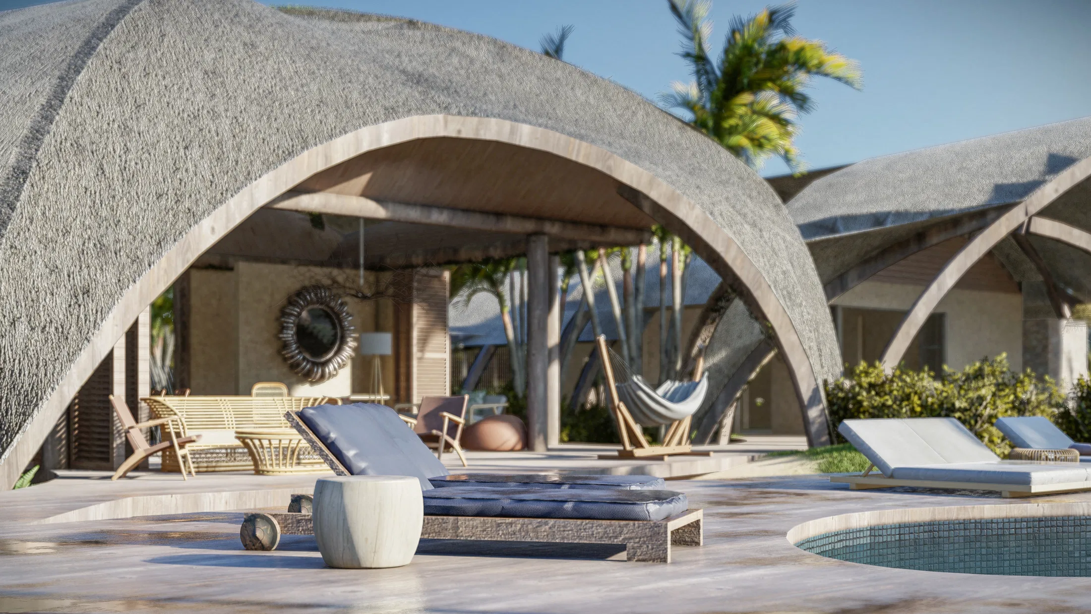 Shaded lounge under a curved shell, with rattan furniture, a round mirror, a hanging chair and a daybed by the pool, open to another pavilion.