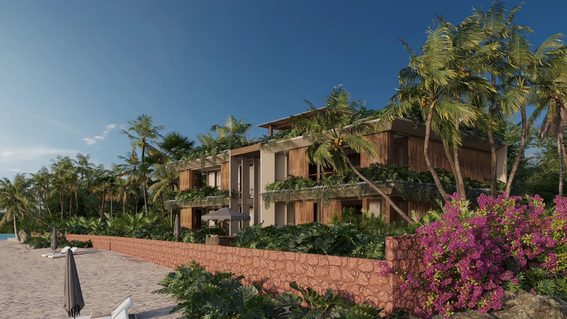 Side render of the inn's building from the beach, featuring landscaped balconies, a textured reddish wall, sun loungers, and blooming bougainvillea.