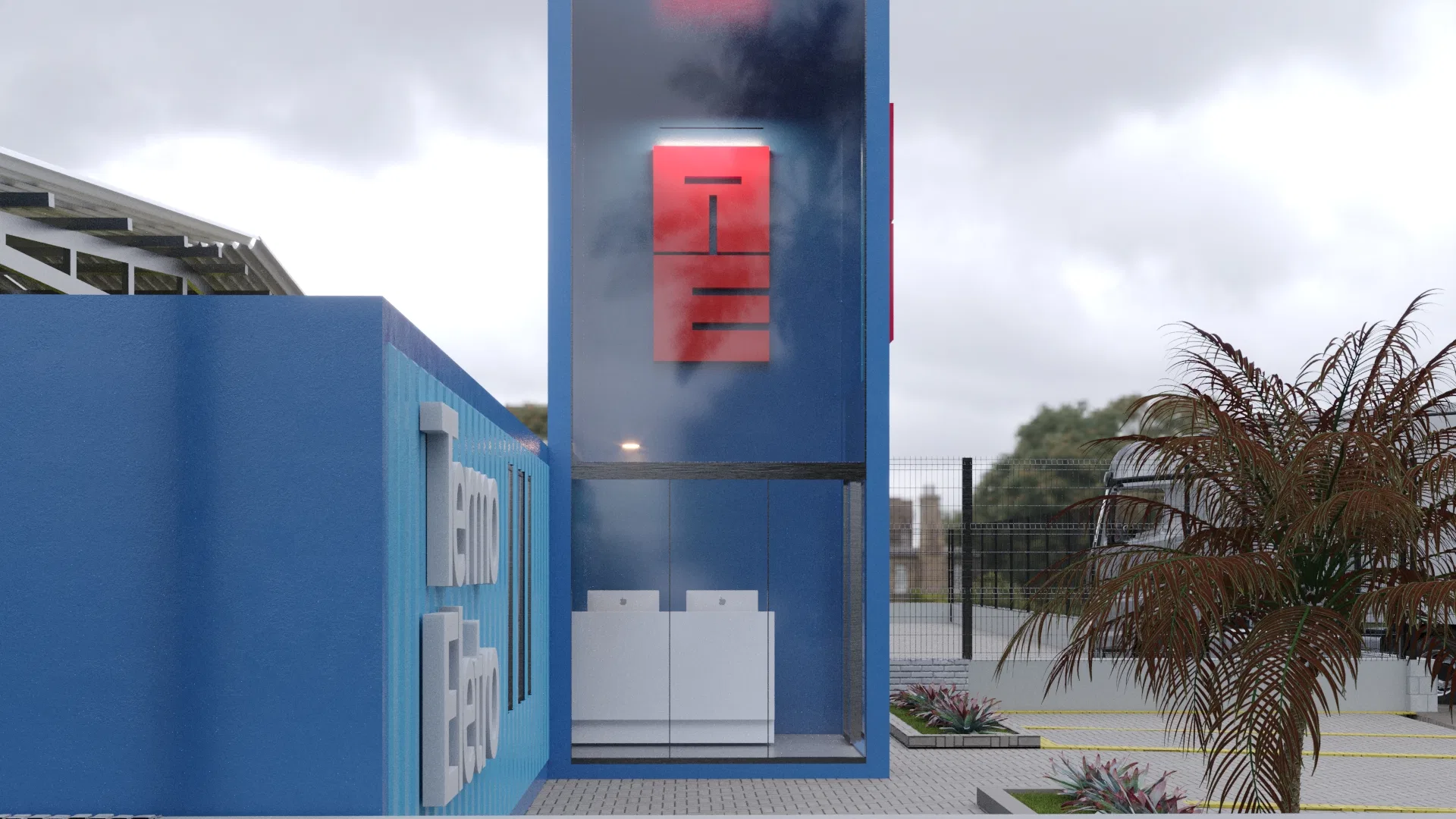 Close-up of the glazed tower with the backlit red monogram reflecting the cloudy sky, white equipment visible on the ground floor and a dry palm to the right
