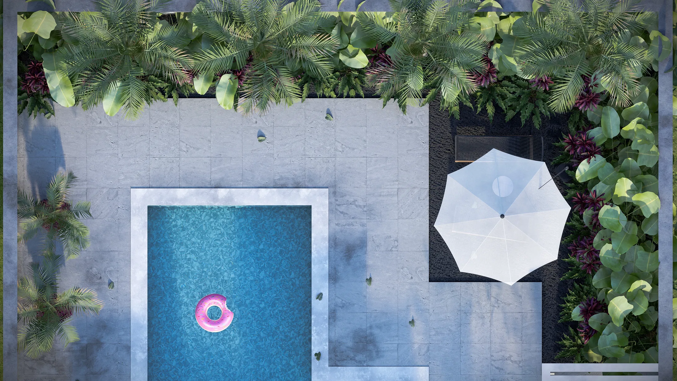 Overhead view of the pool with a pink float, paved deck and a sun umbrella beside the planting bed