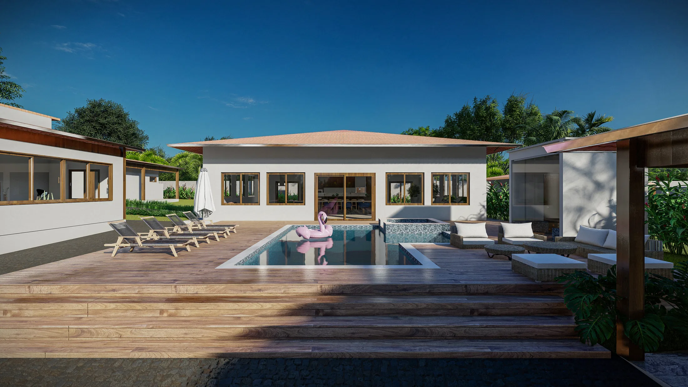 Pool with a wooden deck facing a single-storey pitched-roof house, with sun loungers, a flamingo float and a pergola with a sofa.