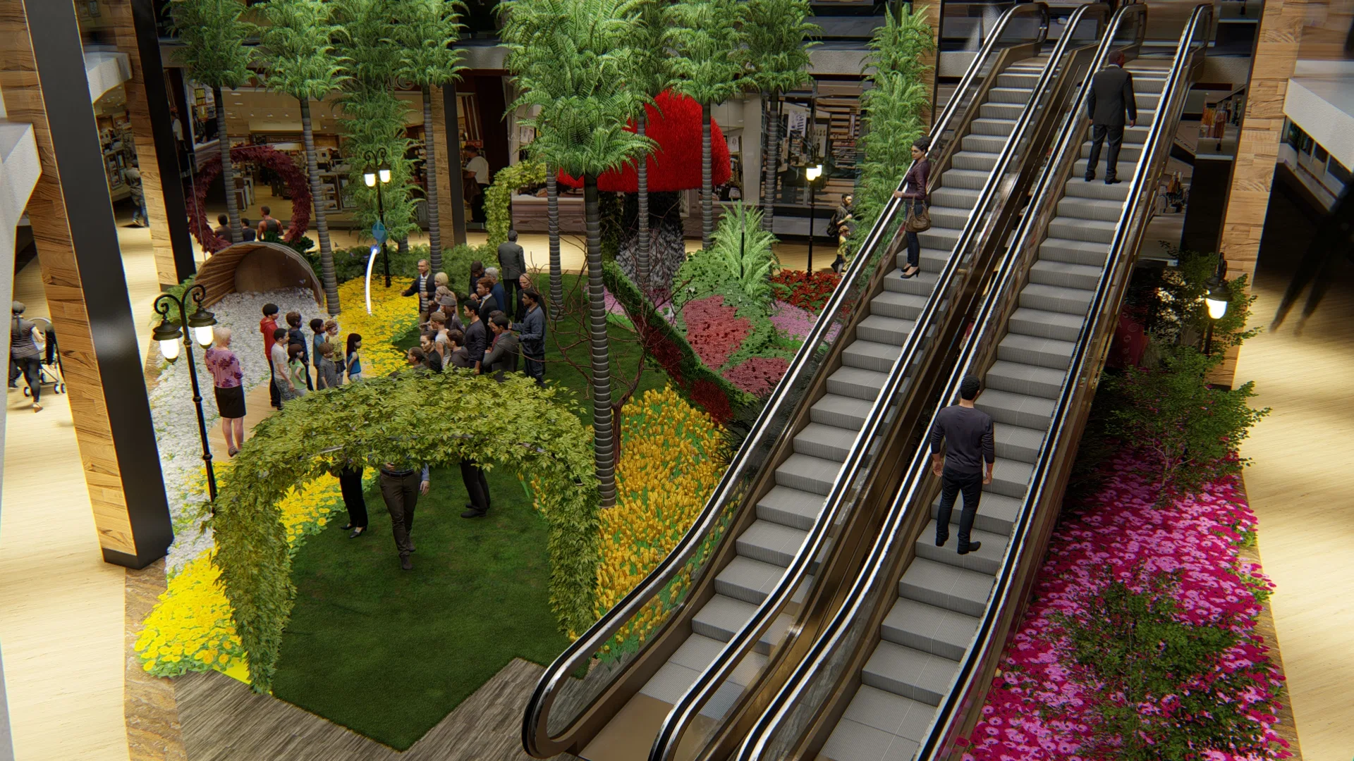 Elevated view of mall escalators flanked by palms, yellow and pink flower beds and a lawn with a vine tunnel where visitors gather