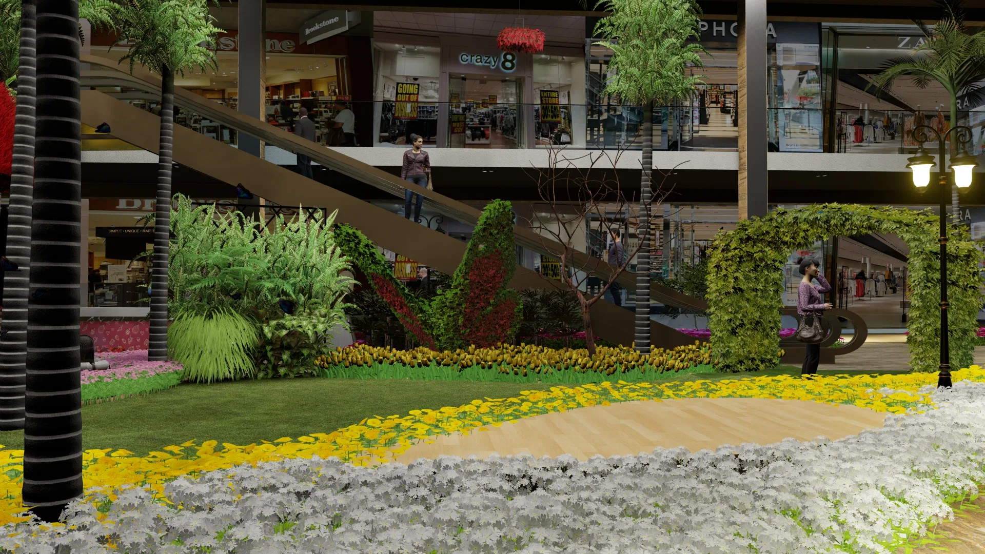 Beds of yellow and white flowers along a curved timber path, with ornamental grasses, topiaries and two levels of shops behind