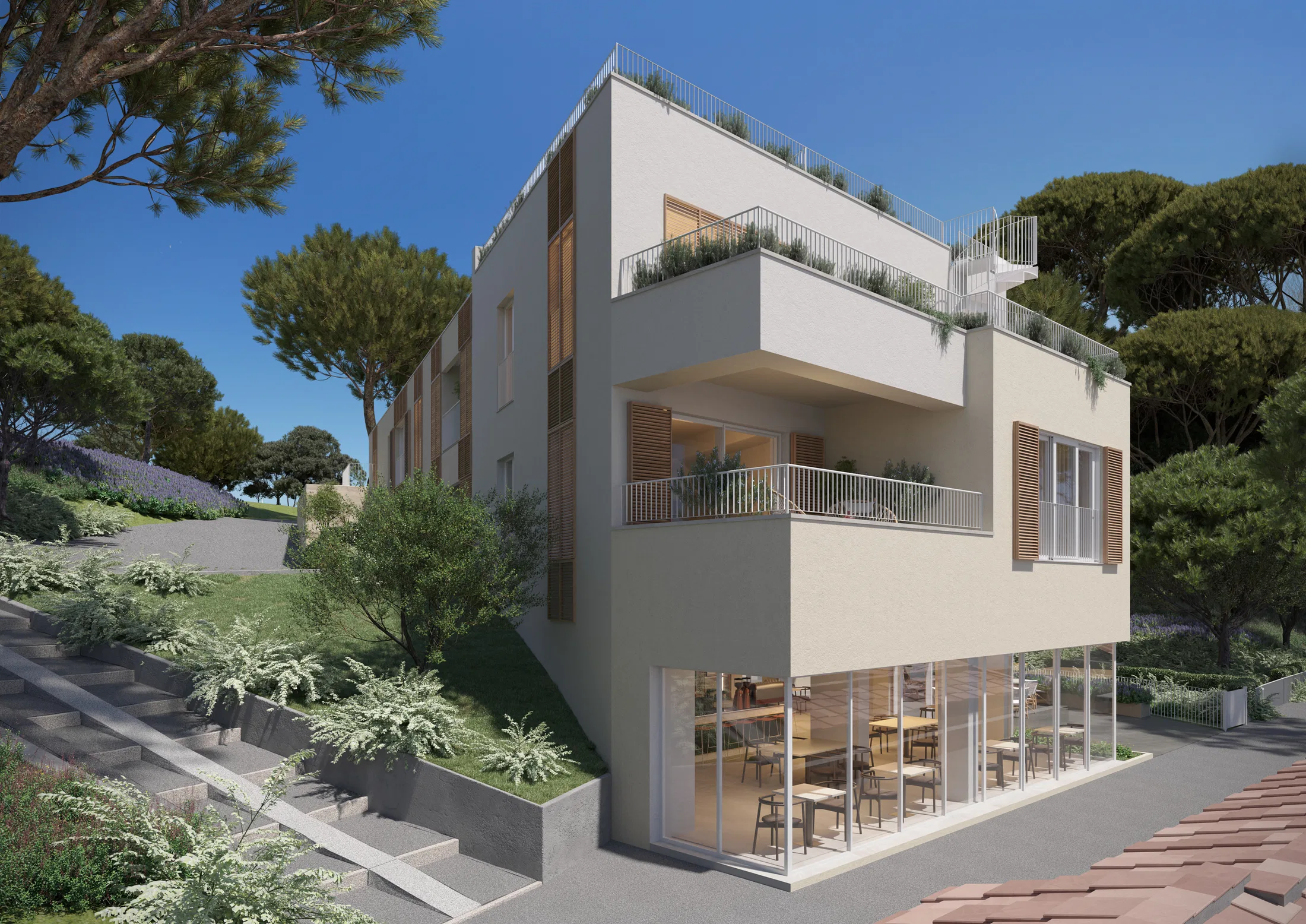 Corner facade of the pale-render building with wooden shutters, planted balconies and a glazed ground-floor café framed by pines
