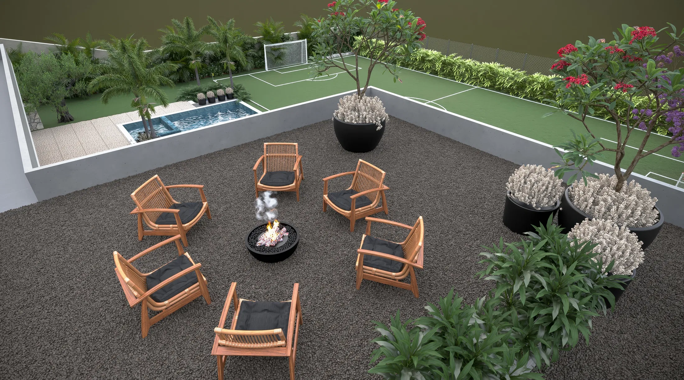 Elevated view of a lounge with wooden armchairs circling a fire bowl, black planters with lavender and trees over a gravel floor