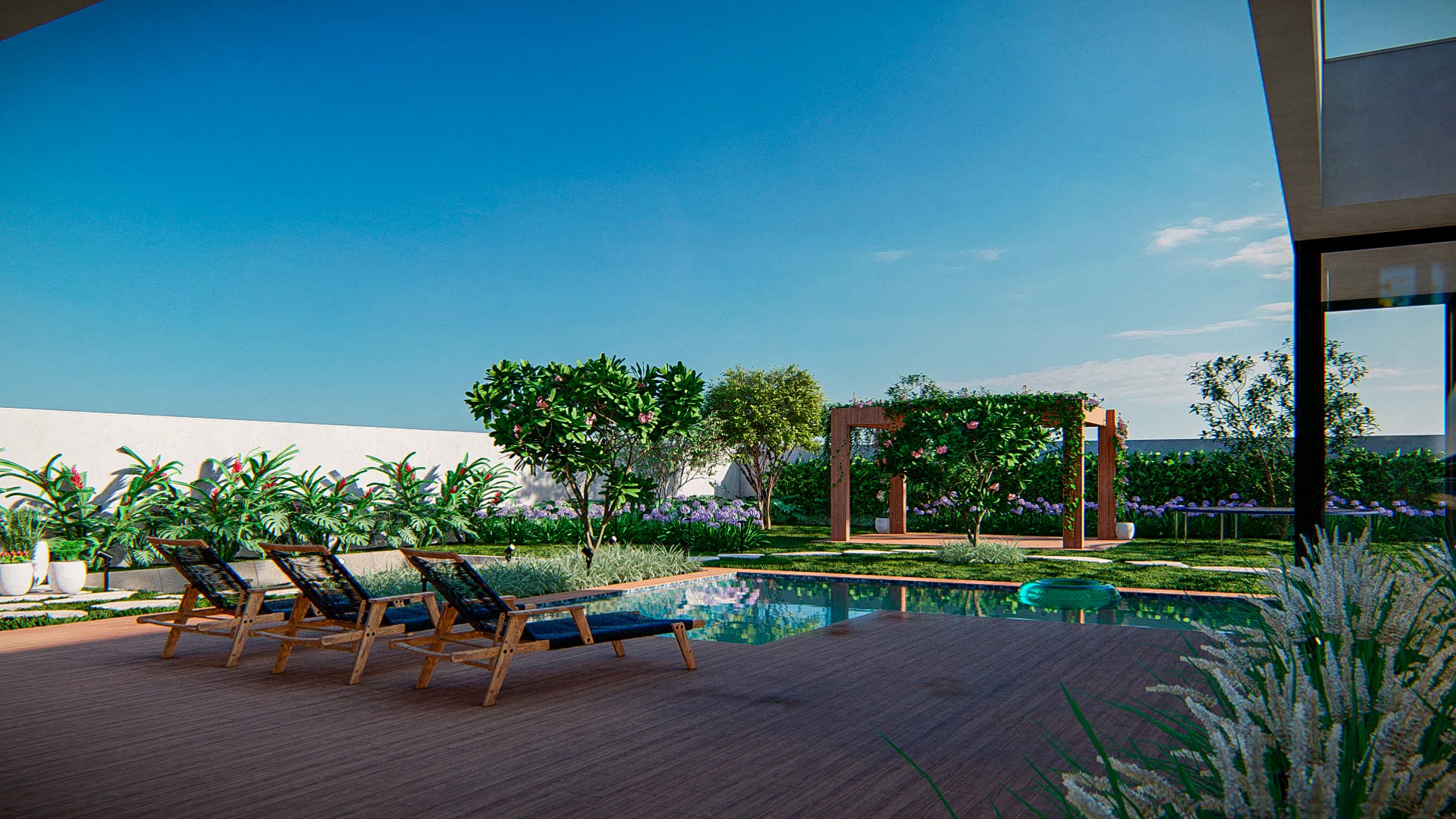 Pool area with a timber deck, straight-backed sun loungers and, in the background, a planted pergola among beds of shrubs and grasses