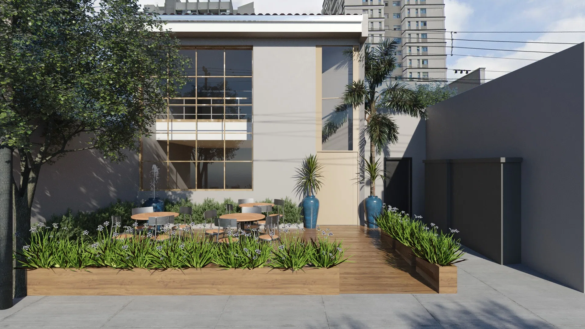 Restaurant facade with a landscaped outdoor courtyard, open-air tables and chairs, a bed of flowering agapanthus and buildings in the background