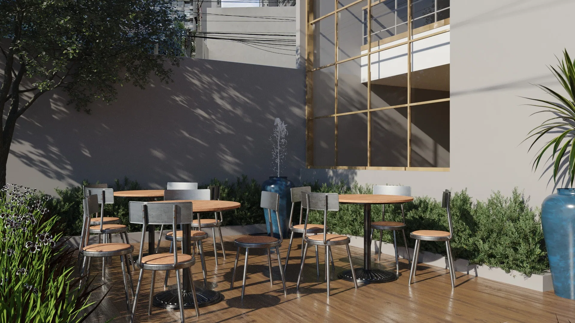 Outdoor courtyard with round tables and metal chairs, a gold-framed window, a blue vase fountain and shrub planting beds