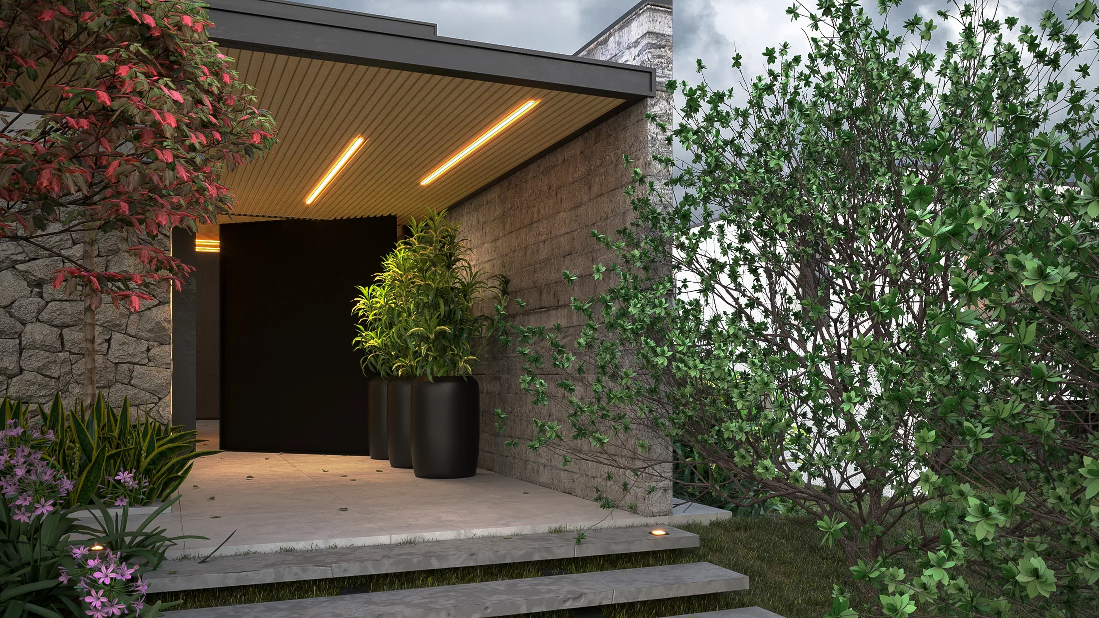 Main entrance with a dark pivot door, stone wall, tall planters of foliage and steps lit by recessed spotlights
