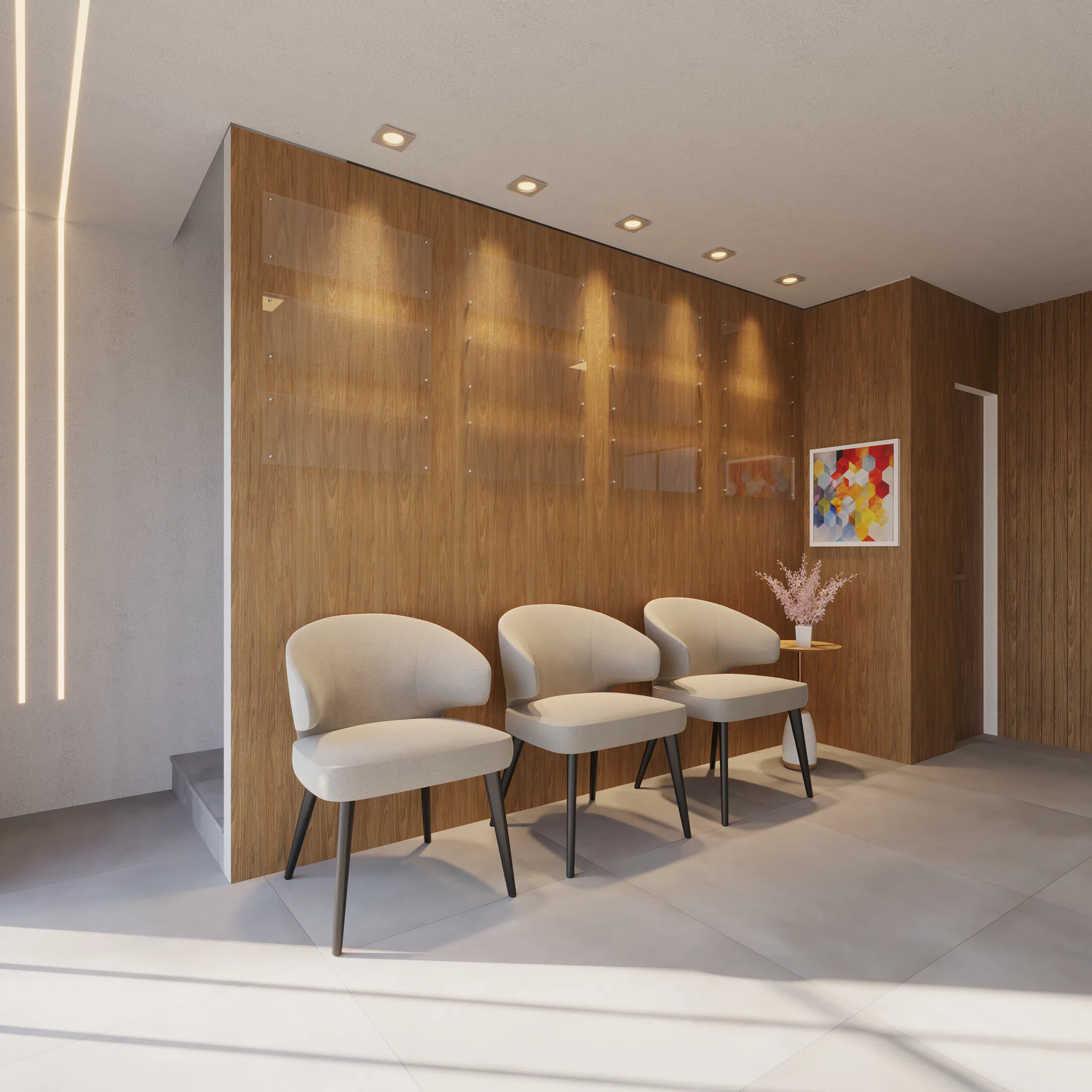 Waiting area seen from an angle, with light-gray upholstered chairs, a wood wall with backlit frames and a colorful artwork beside a side table