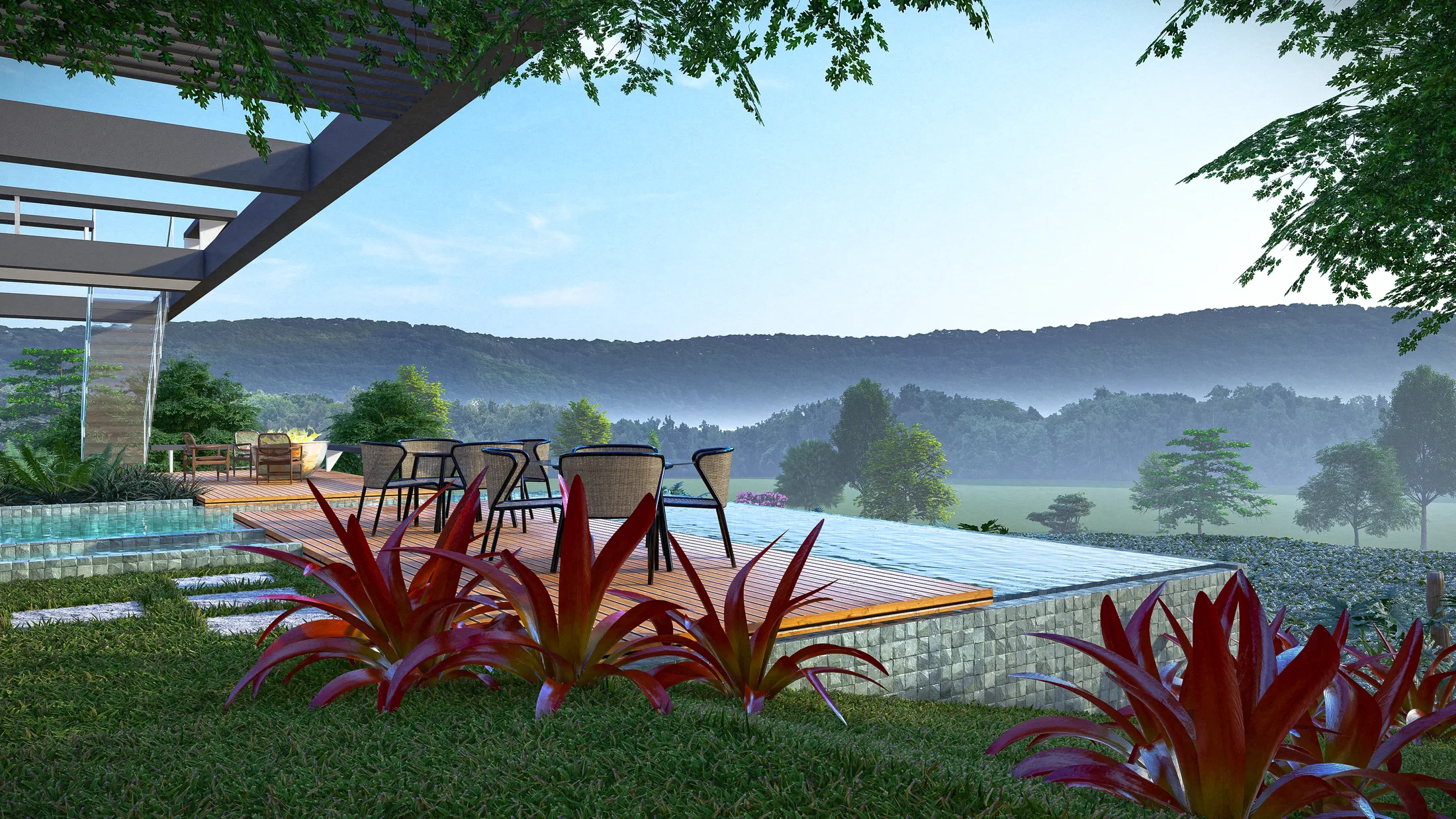 Infinity-edge pool deck with an outdoor lounge under a pergola, red bromeliads on the lawn in the foreground and misty mountains beyond