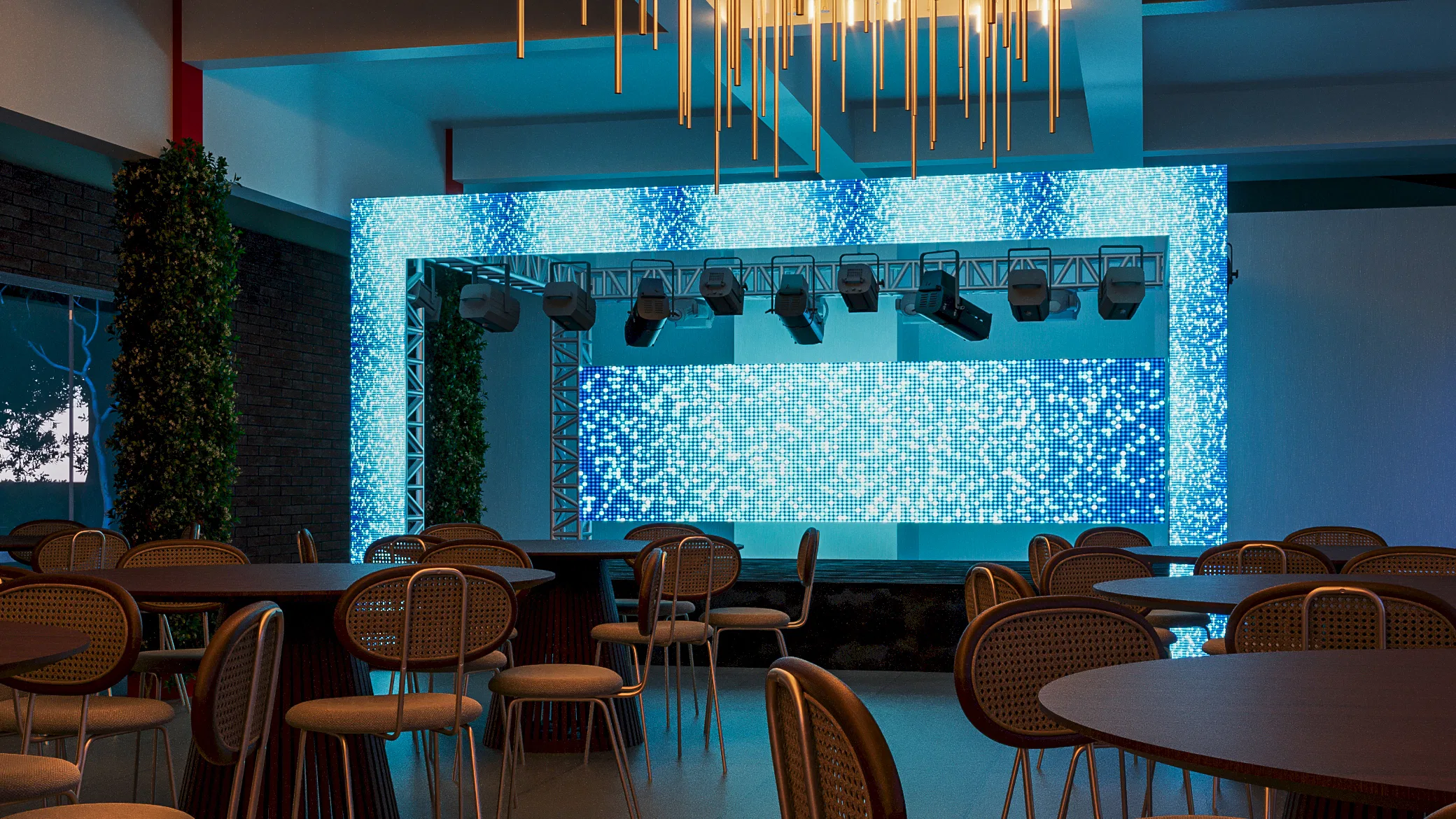 Event hall with a shimmering blue LED wall and truss-mounted spotlights, round tables with cane chairs under a golden-rod chandelier