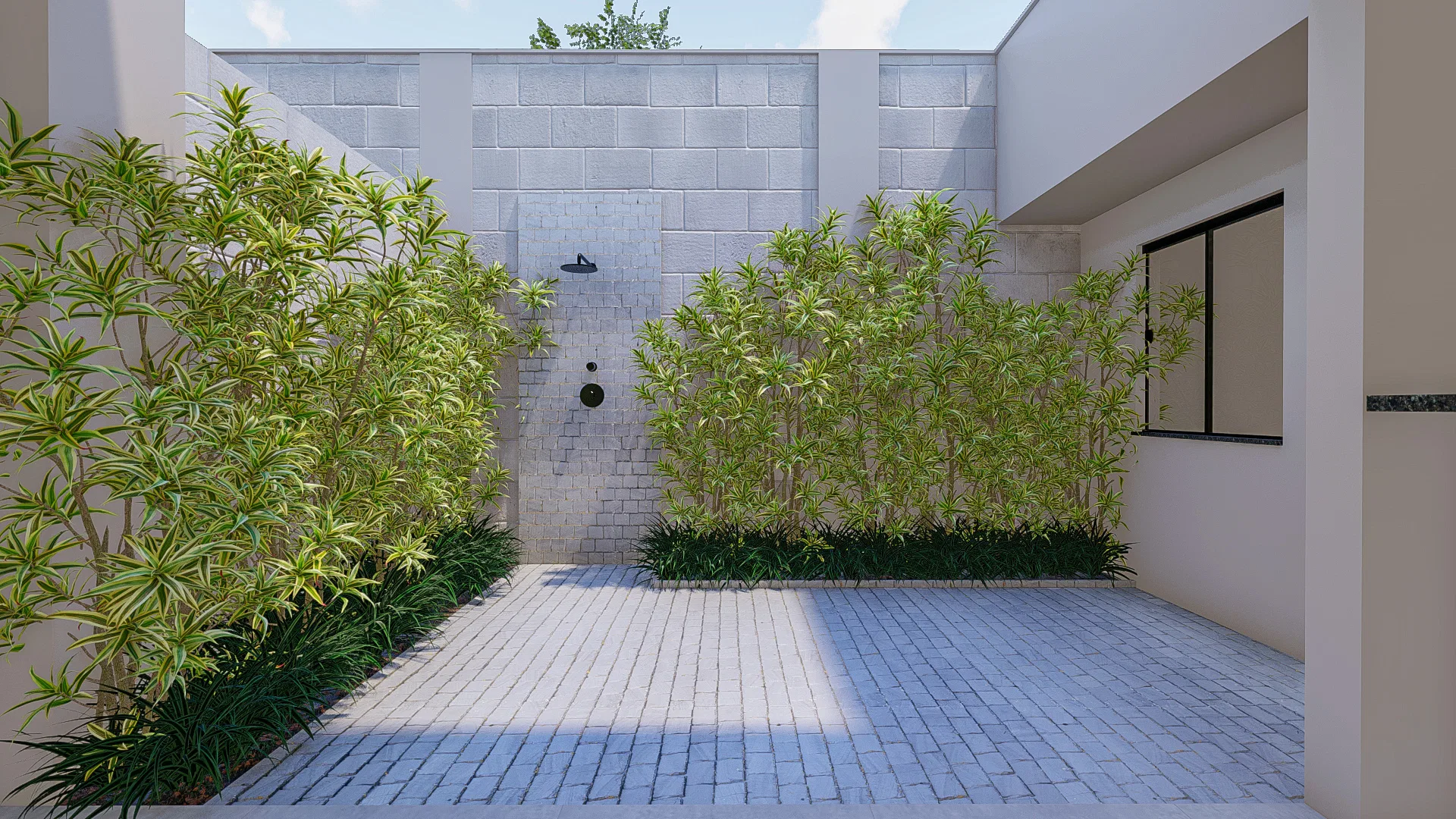 Open-air shower courtyard with a fixture on an exposed concrete-block wall and light stone paving, flanked by beds of tropical foliage