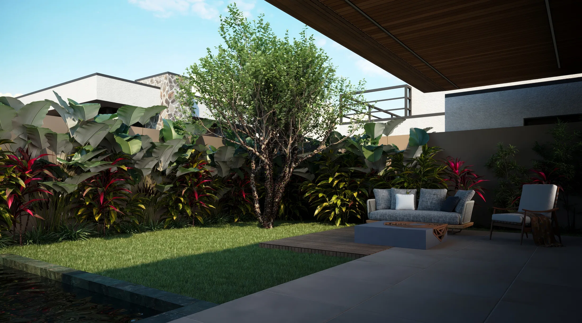 Outdoor living area with a sofa and armchair on large-format paving, facing a lawn, a tree and dense foliage