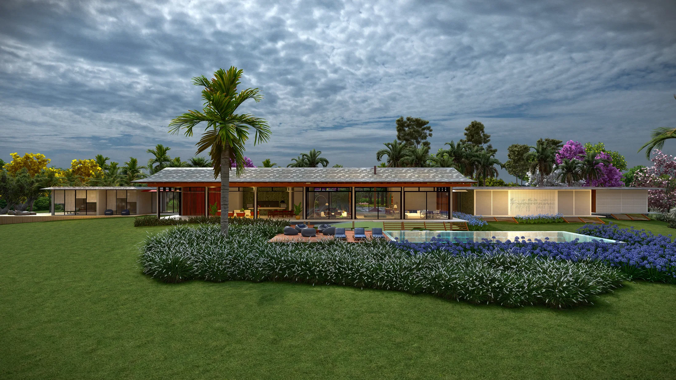 Single-story house facade at dusk with a pool framed by agapanthus beds, a central palm tree and warm interior lighting