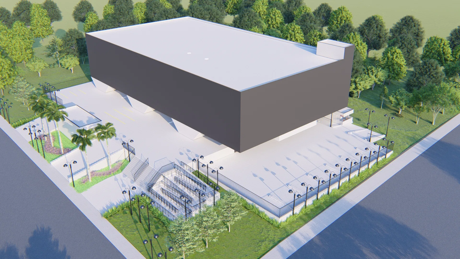Aerial view of the site, showing the grey warehouse volume, parking, a fenced outdoor grandstand, palm trees and surrounding roads.