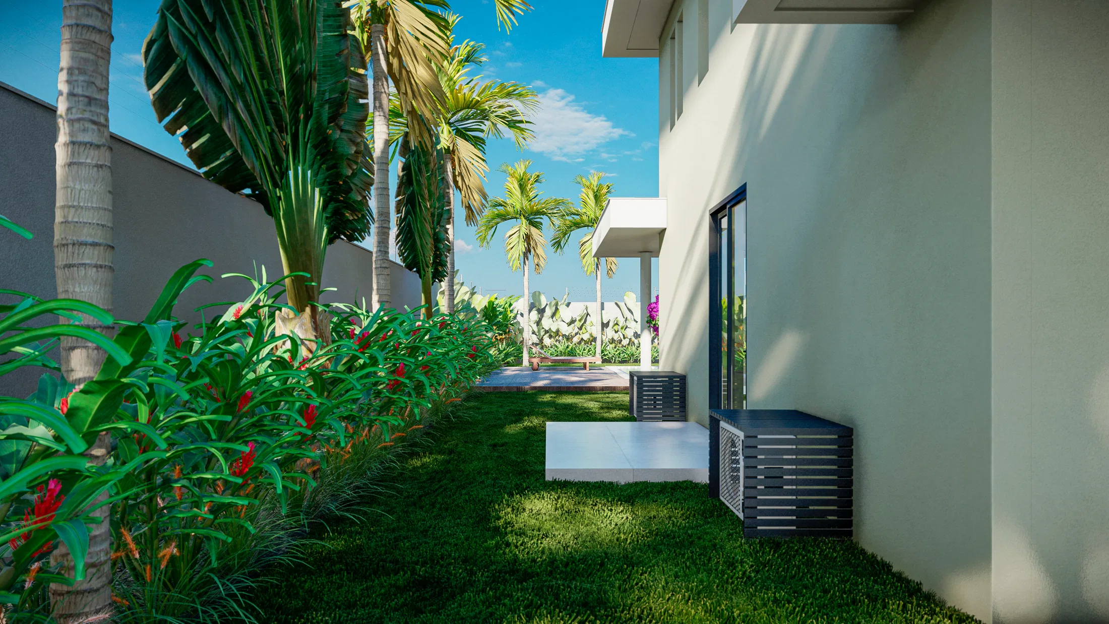 Grassed side passage along the house wall, with condenser units, a bed of red bromeliads and palms in the background