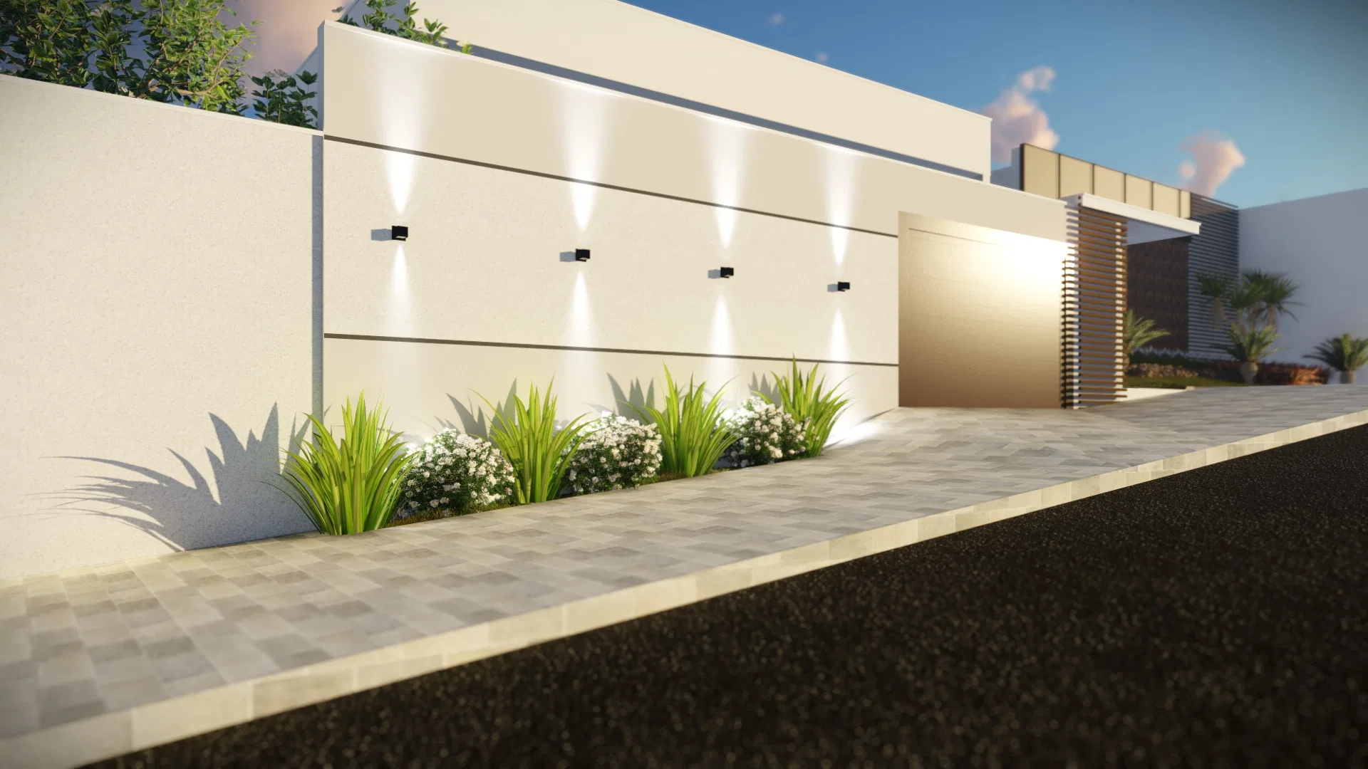 White wall with recessed uplights over a bed of grasses and white flowers, next to the entrance gate and interlocking-paver sidewalk