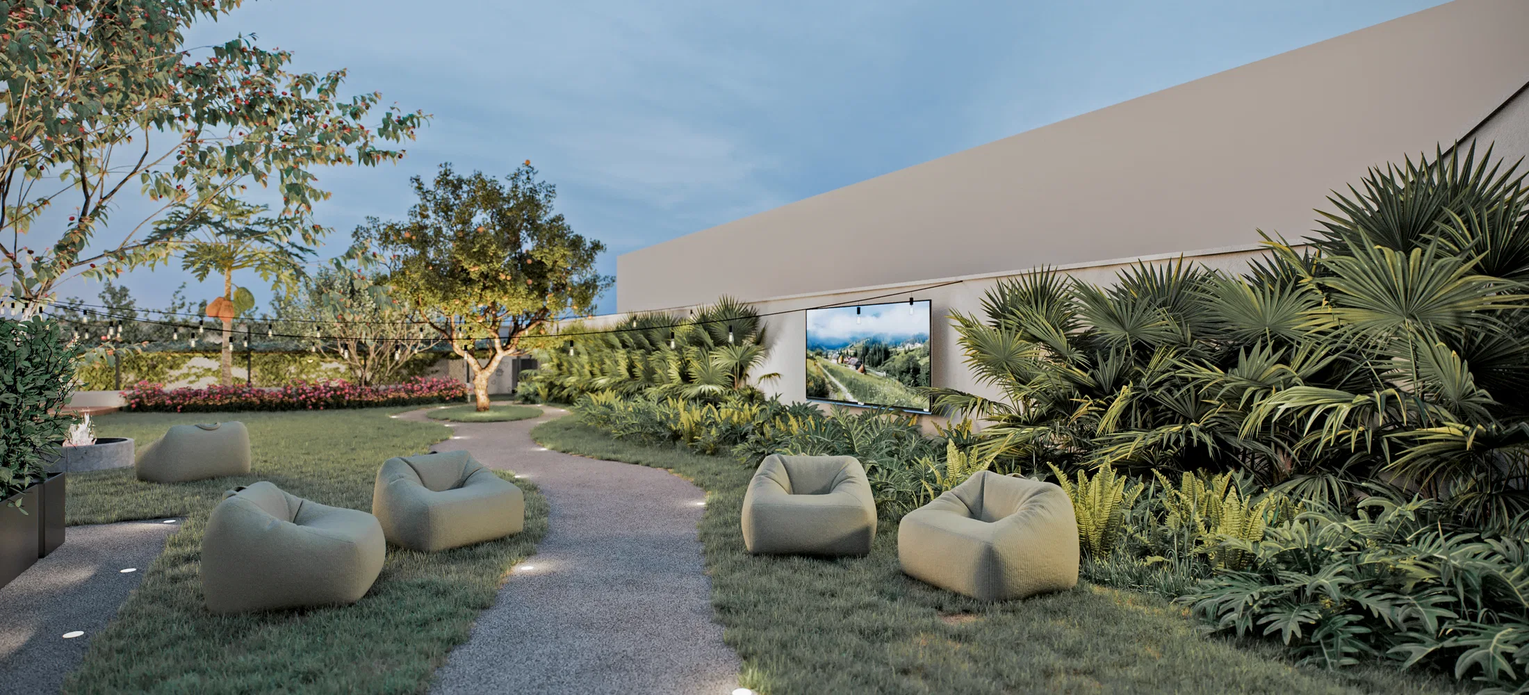 Lawn at dusk with scattered green bean-bag chairs, a stone path, dense palms on the right and a light-toned volume with an opening behind.