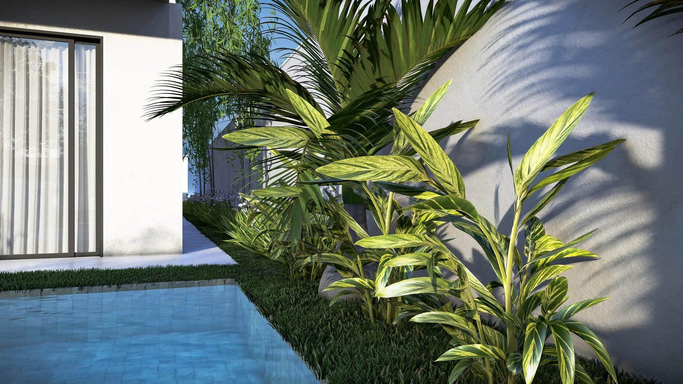 Side corridor with a bed of variegated green-and-yellow foliage, boulders and palm fronds beside the pool edge