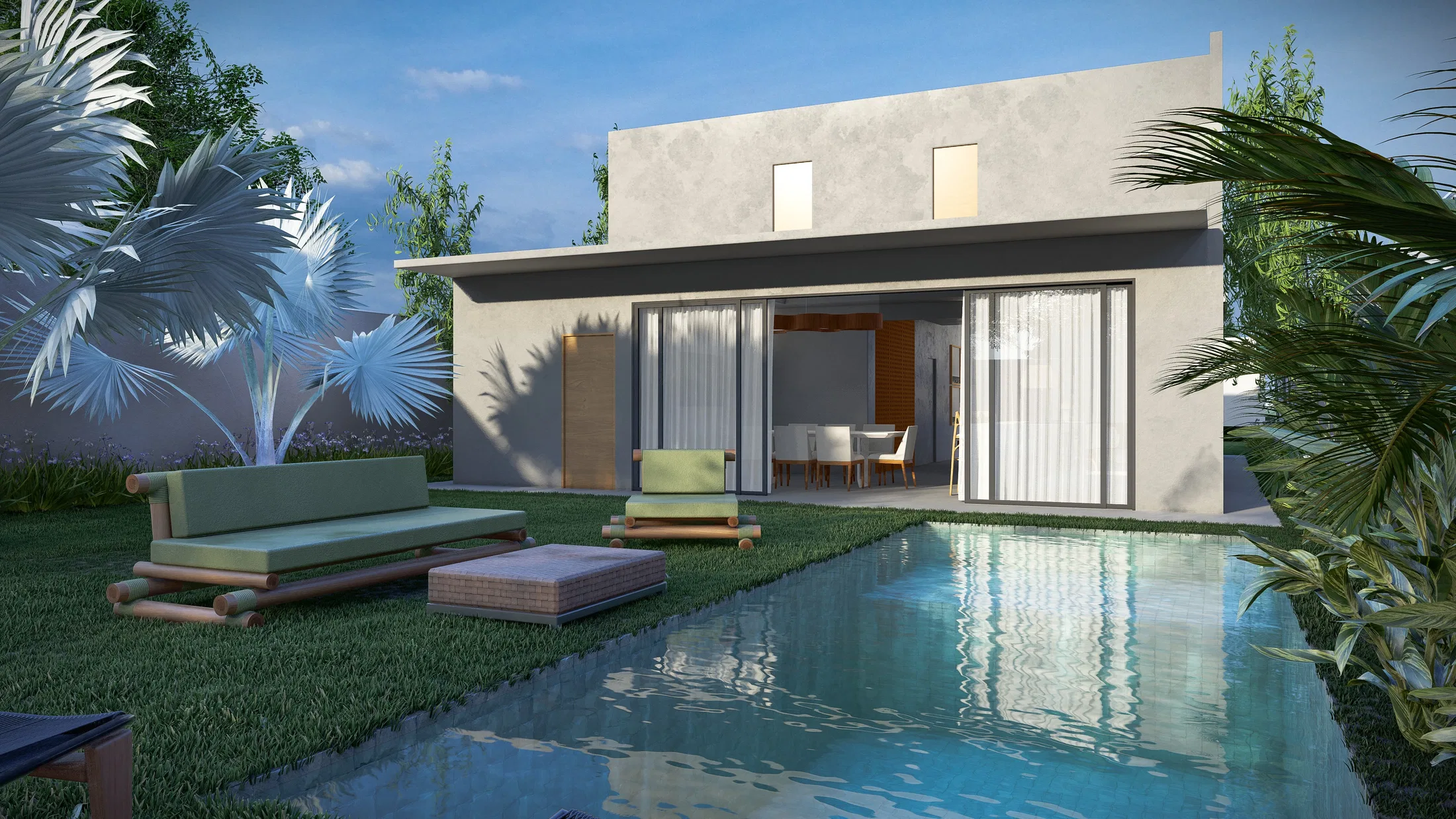 Backyard at twilight with a glass facade, a green daybed on the lawn and a long pool bordered by tropical planting