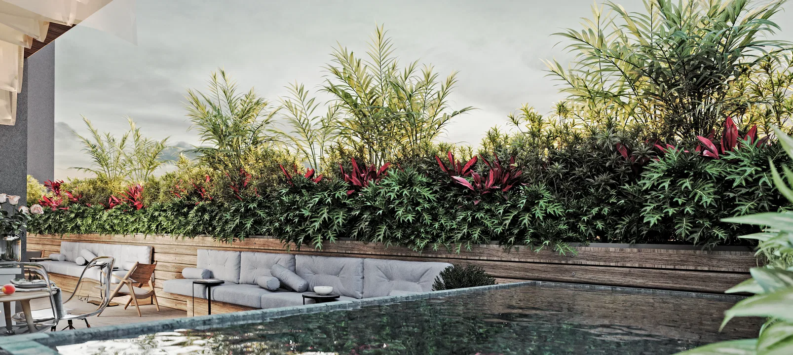 Dark-edged plunge pool reflecting the sky, framed by a wooden planter of palms, ferns and cordyline, with a low sofa and teak chairs alongside.