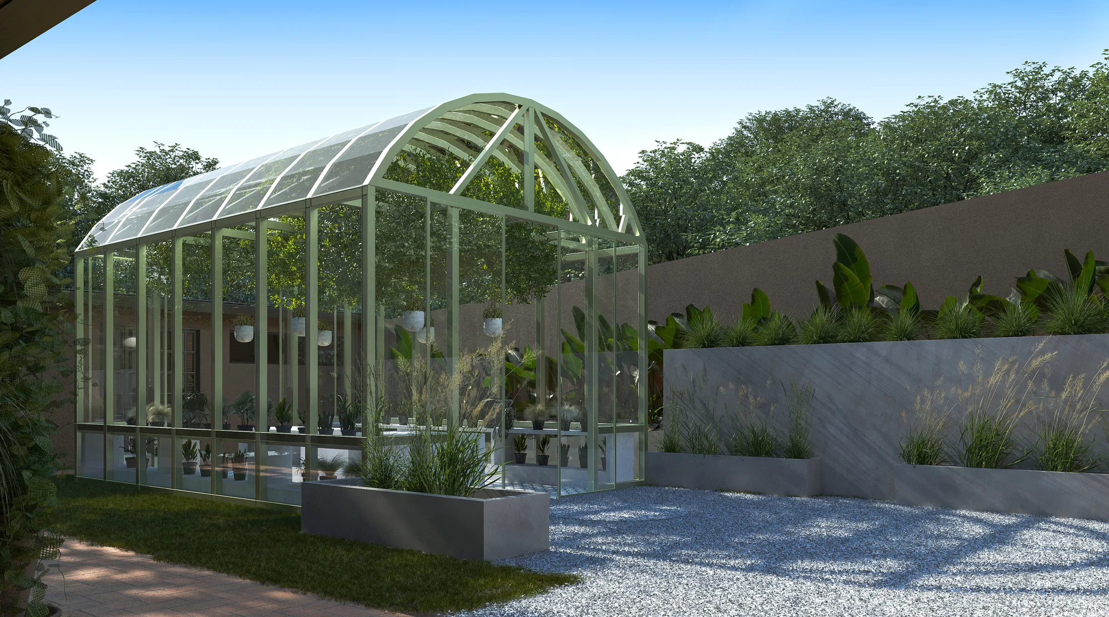 Arched greenhouse of glass and pale-green metal framed by concrete planters with grasses, on a gravel floor beside a grey wall
