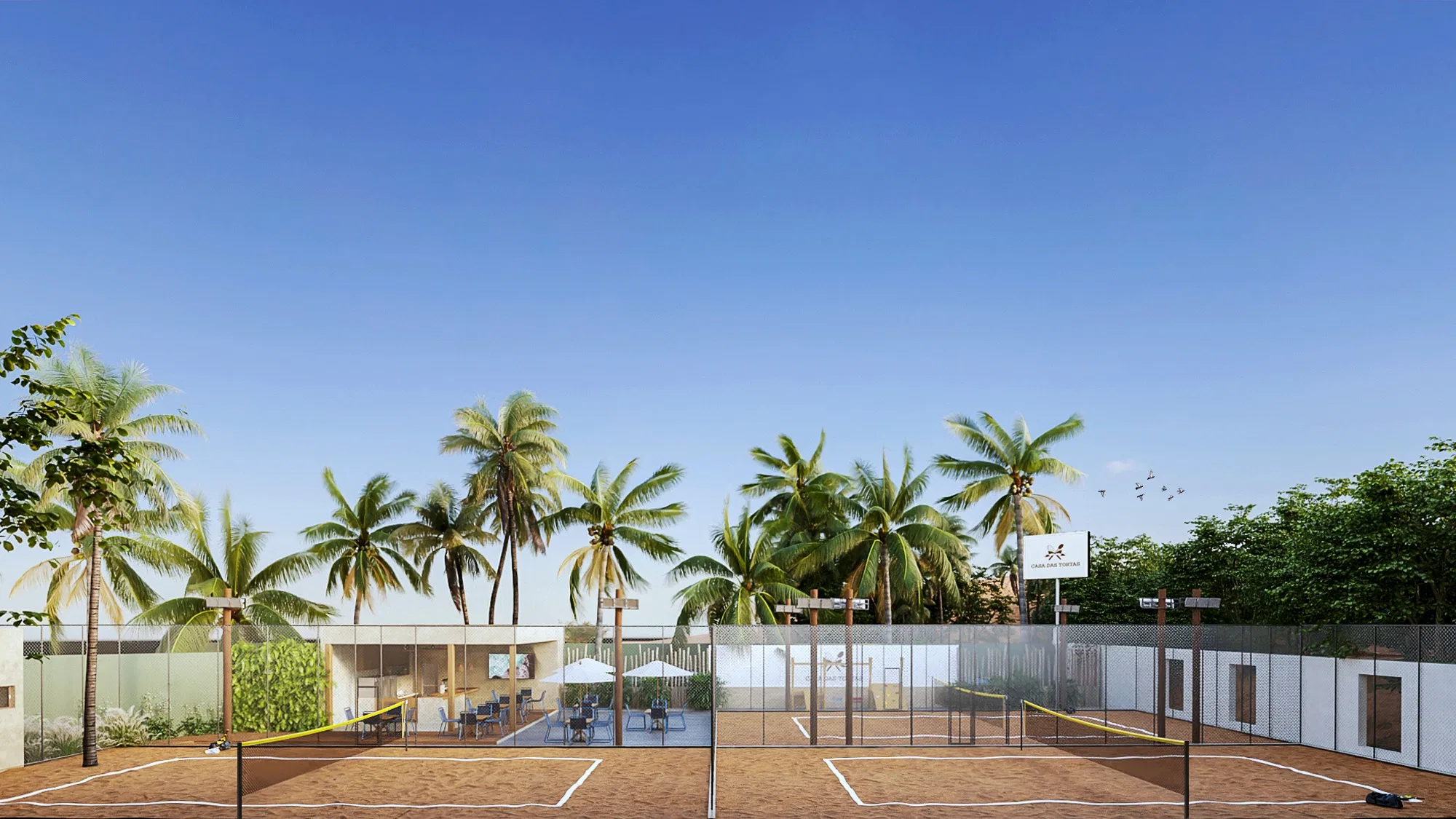 Wide view of the complex with two sand courts side by side, coconut palms behind and the central lounge core with a green wall and parasols