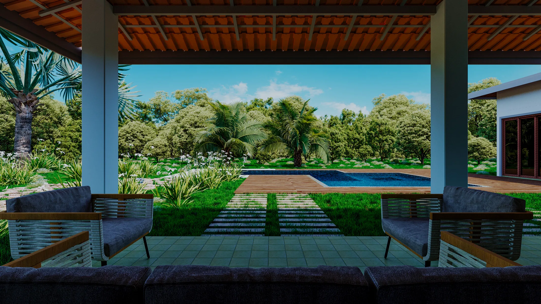 View of a pool framed by dense greenery, seen from a covered deck with lounge seating.
