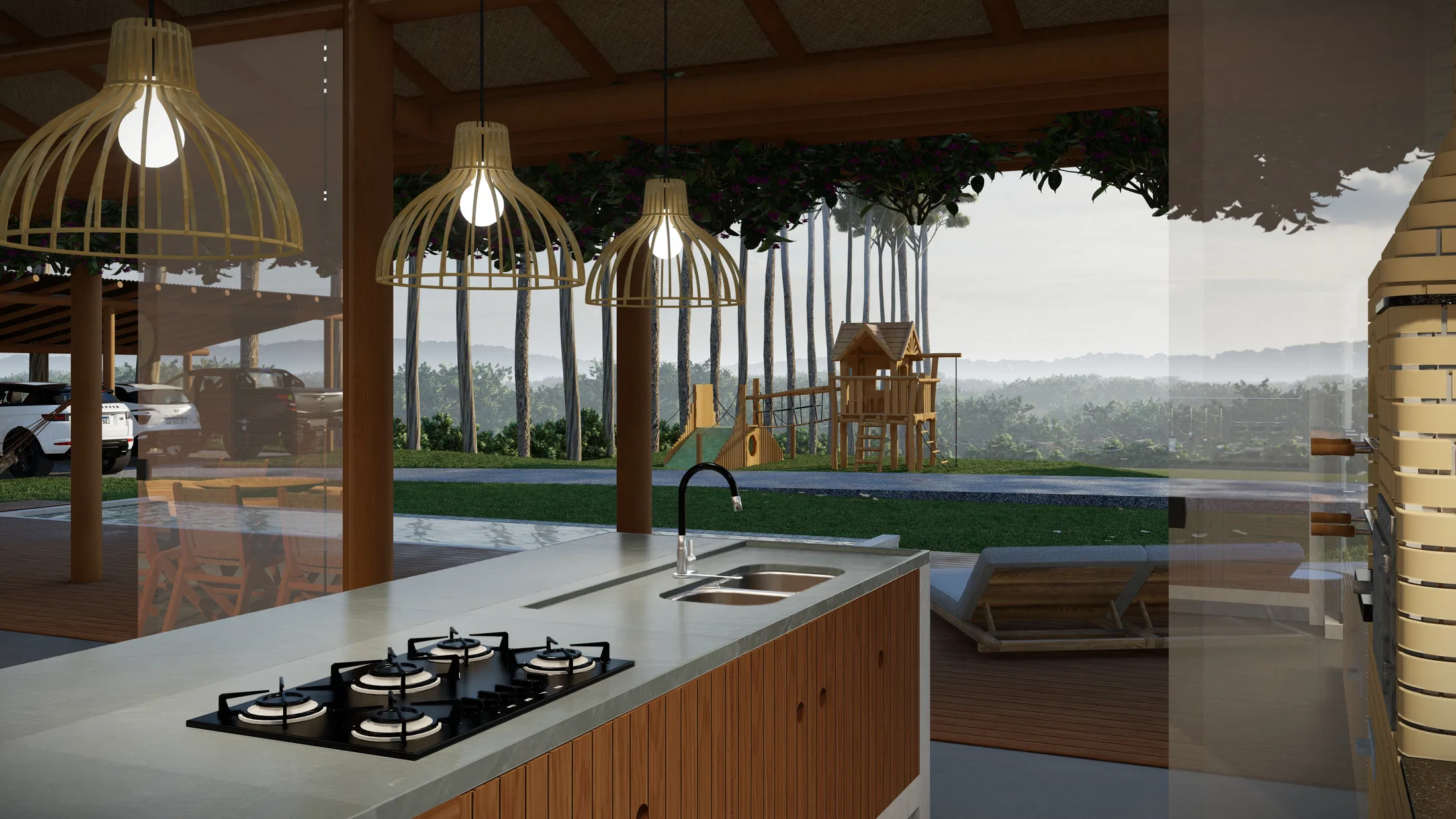 Kitchen island with cooktop and sink, seen through glass toward a wooden playground and pool beyond