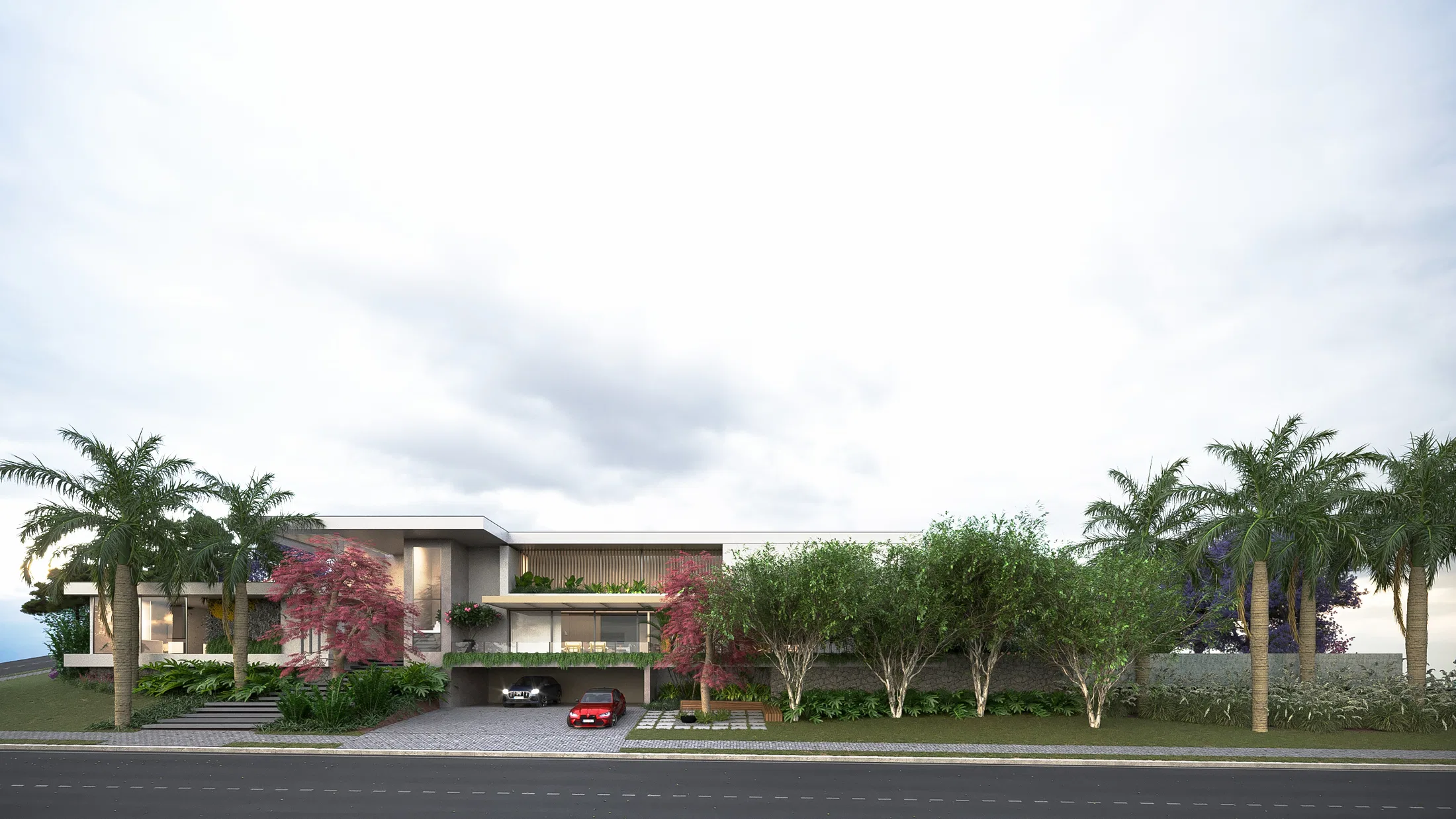 Long horizontal street elevation of the home flanked by royal palms, a red maple and shrub beds under an overcast sky